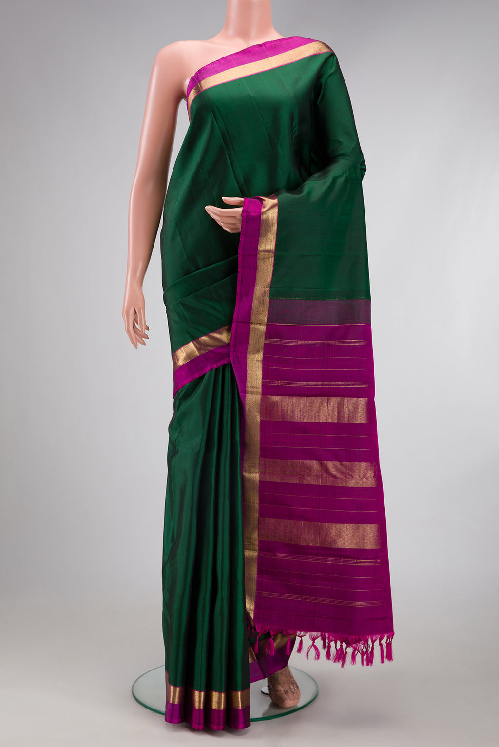 Bottle Green Kanjivaram Silk Saree with Plain Body and Zari Border.  displayed on a mannequin