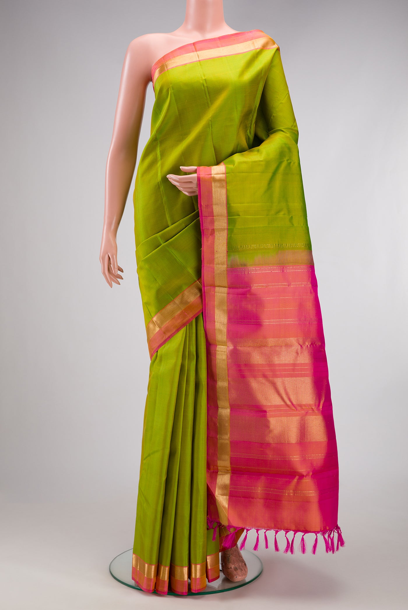 Parrot Green Kanjivaram Silk Saree with Plain Body and Zari Border.  displayed on a mannequin