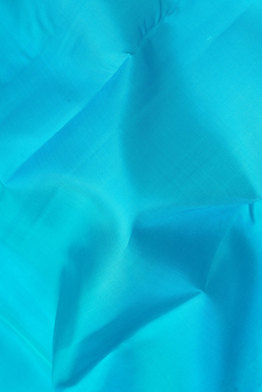 Close up of Light Blue Kanjivaram Silk Saree with Plain Body and Zari Border.  displaying folds