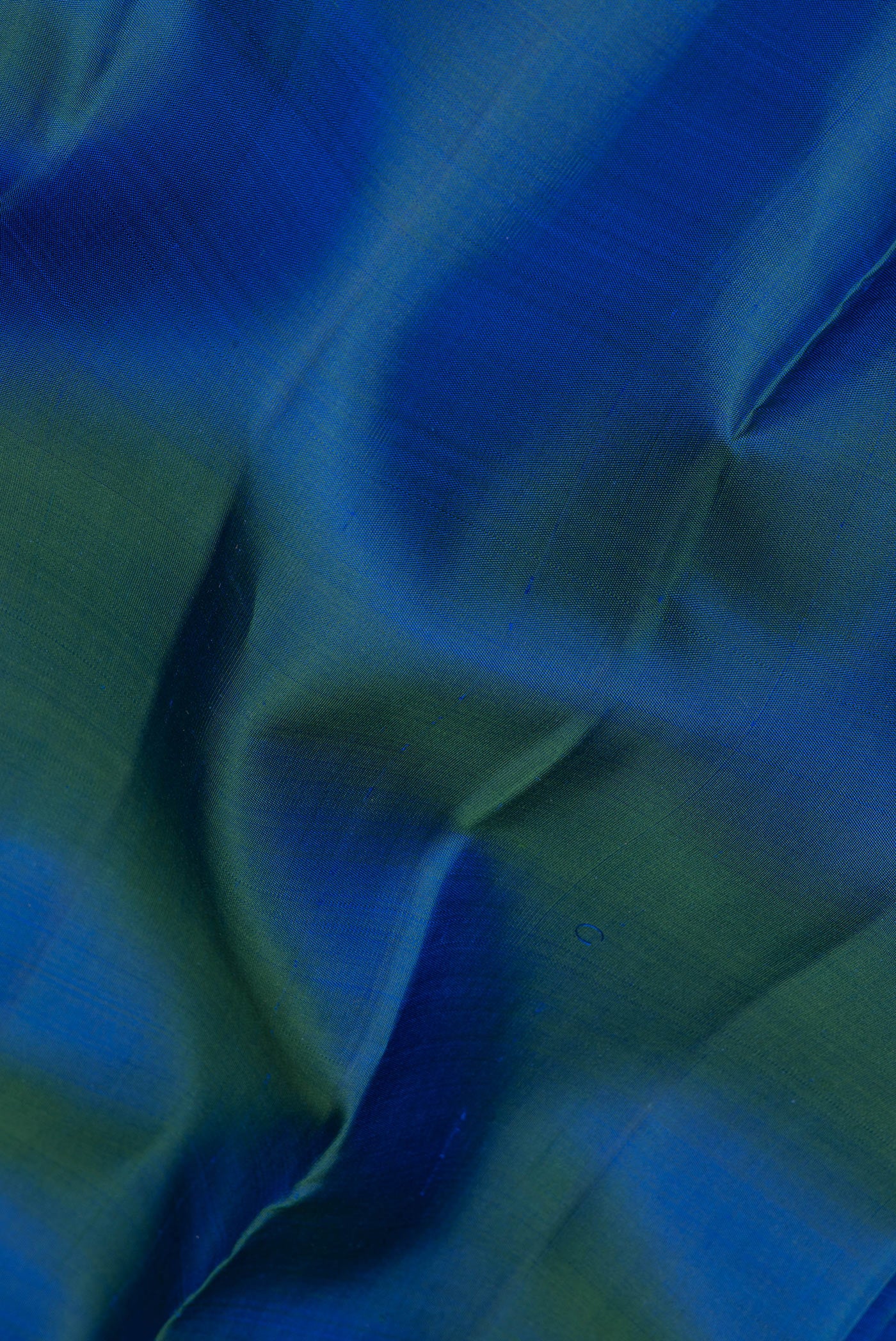 Close up of Peacock Blue Kanjivaram Silk Saree with Plain Body and Zari Border.  displaying folds