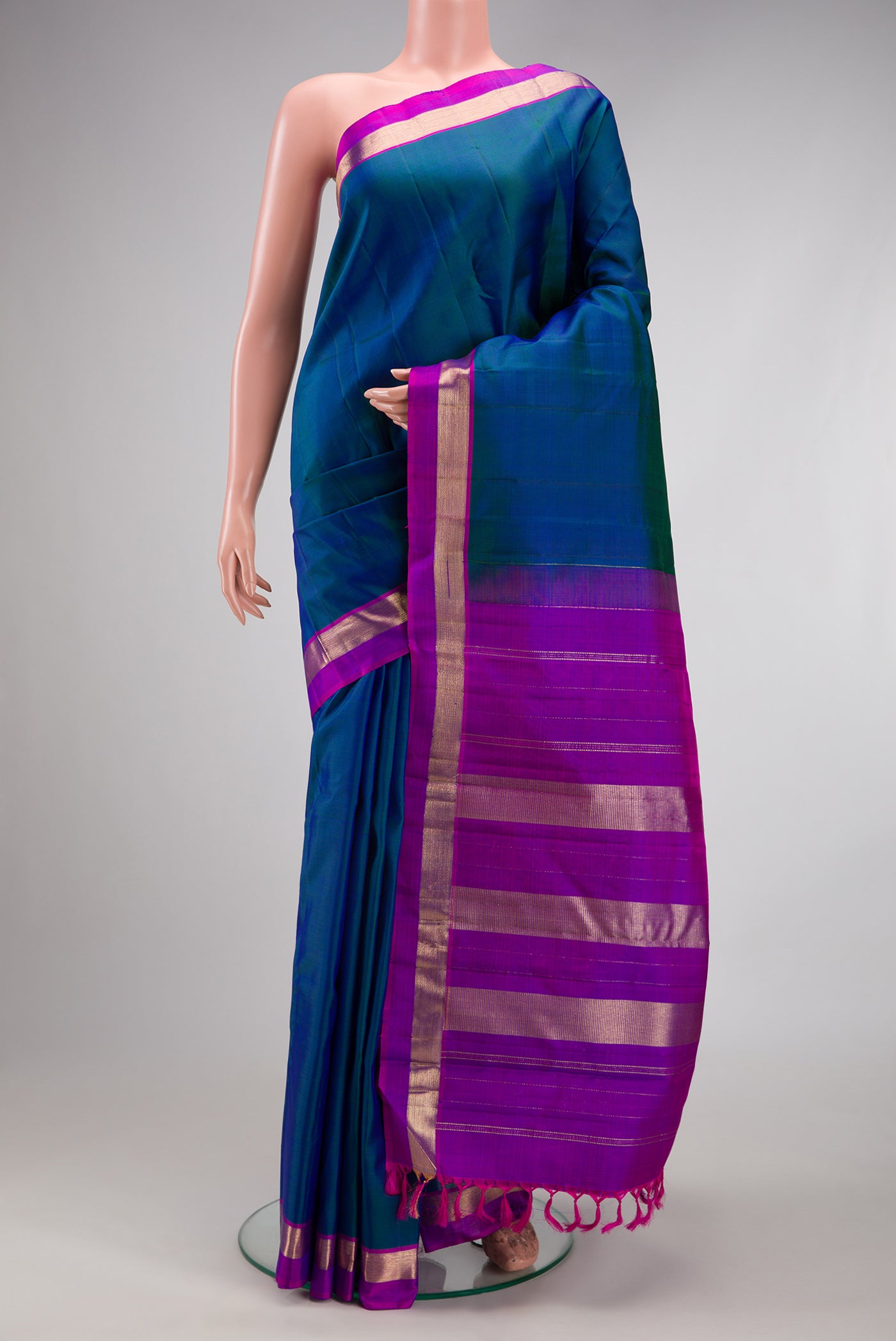 Peacock Blue Kanjivaram Silk Saree with Plain Body and Zari Border.  displayed on a mannequin