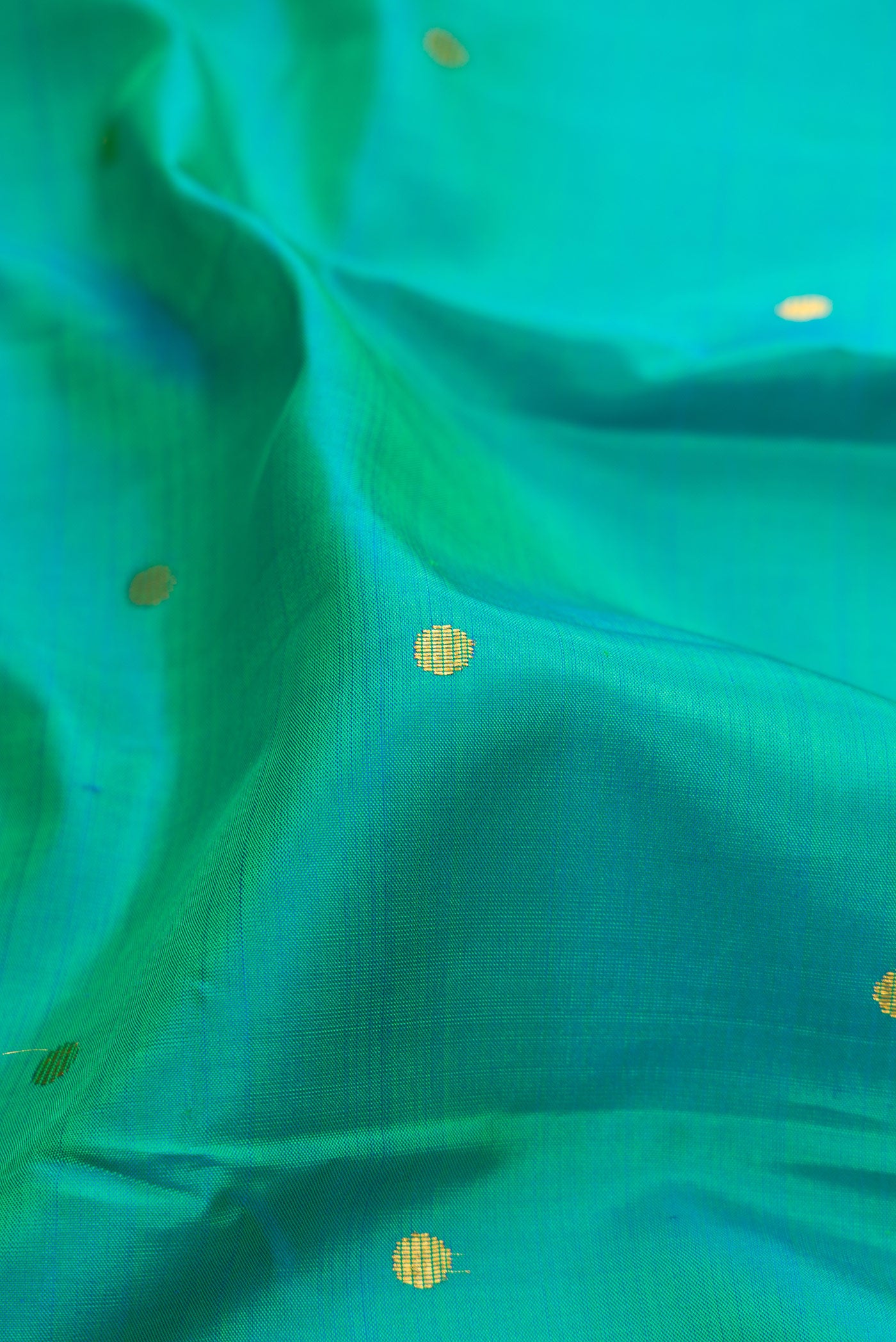Close up of Sea Green Kanjivaram Silk Saree with Zari Butta on the body and Zari Border.  displaying folds