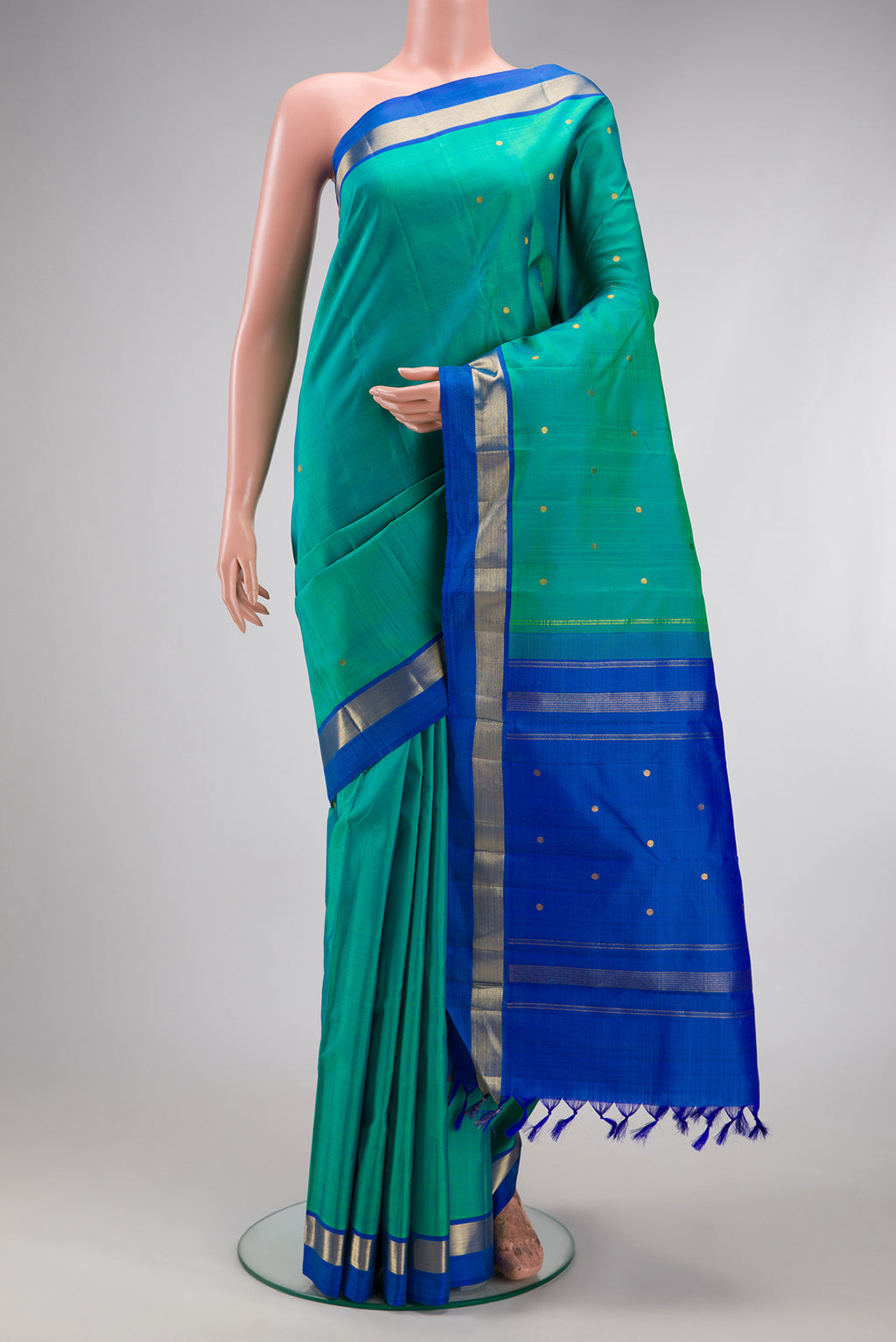 Sea Green Kanjivaram Silk Saree with Zari Butta on the body and Zari Border.  displayed on a mannequin