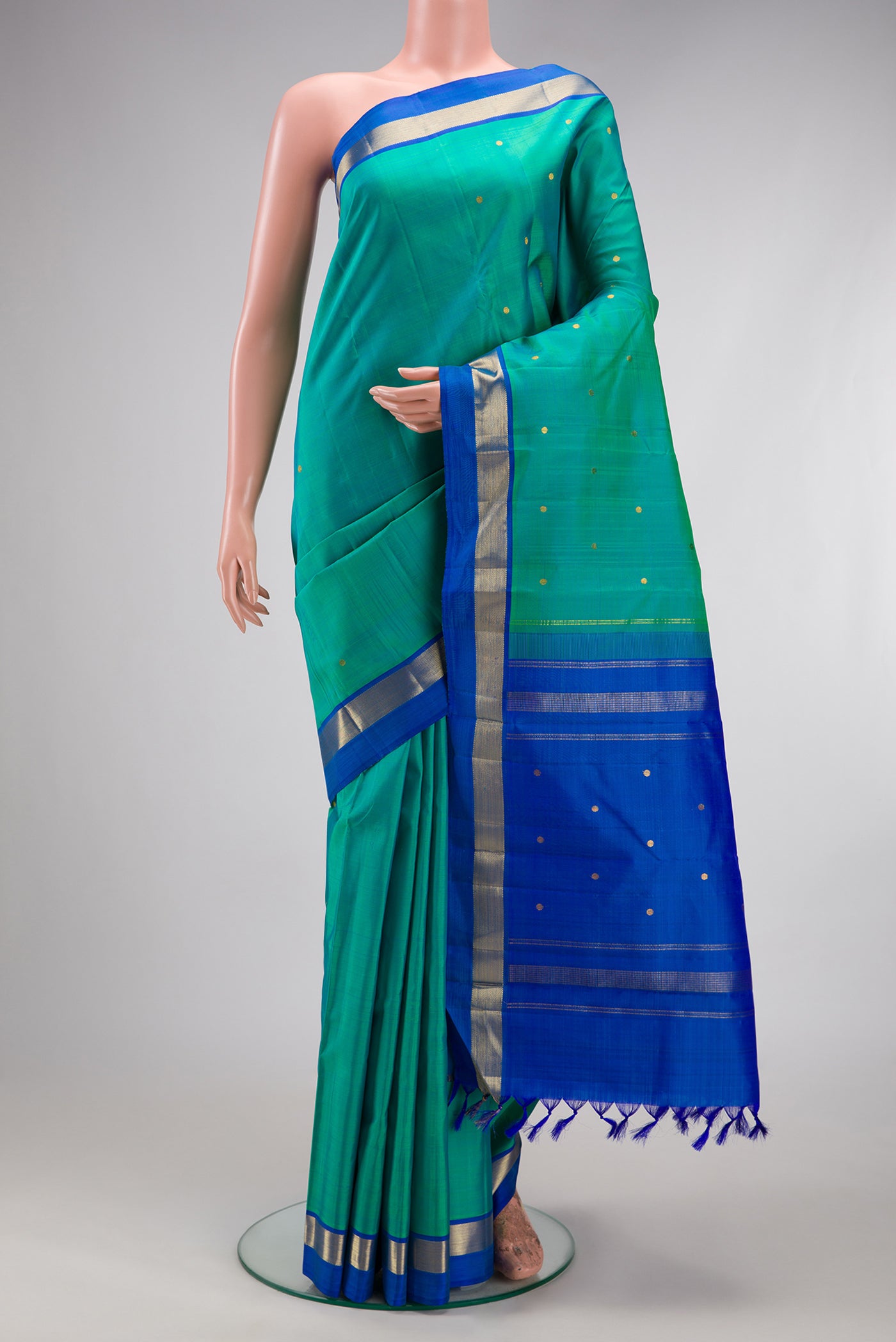 Sea Green Kanjivaram Silk Saree with Zari Butta on the body and Zari Border.  displayed on a mannequin