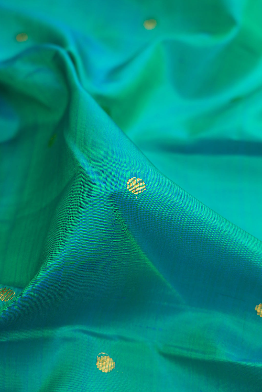 Close up of Sea Green Dual Tone Kanjivaram Silk Saree with Zari Butta on the body and Zari Border.  displaying folds