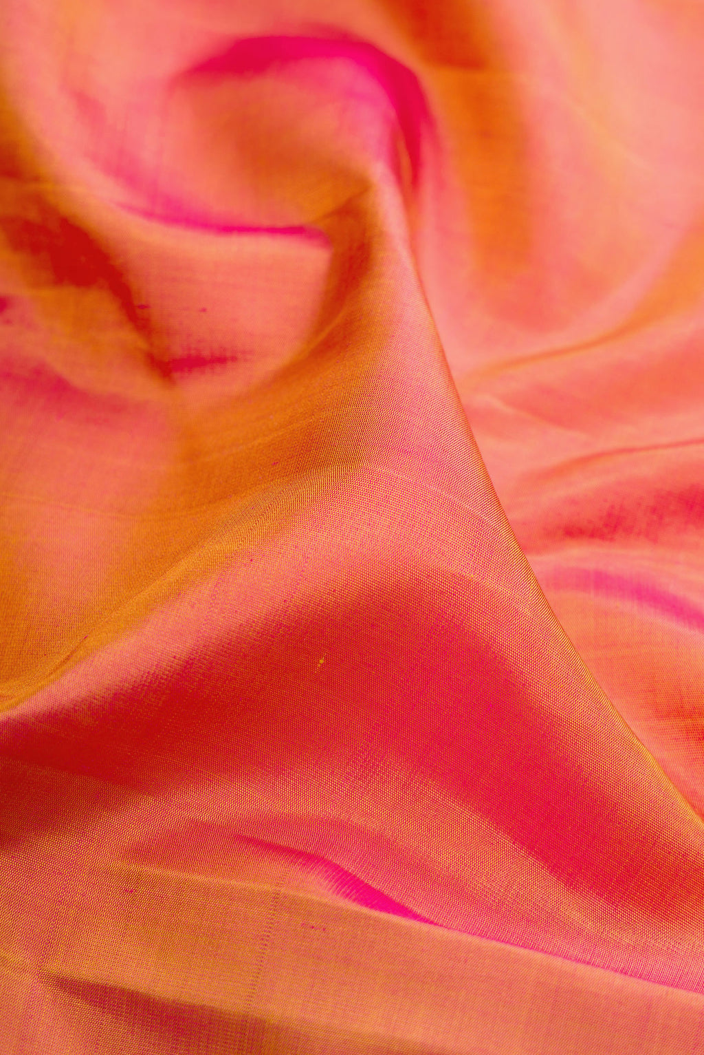 Close up of Pinkish Yellow Dual Tone Kanchipuram Silk Saree with Plain Body and Fancy Border.  displaying folds