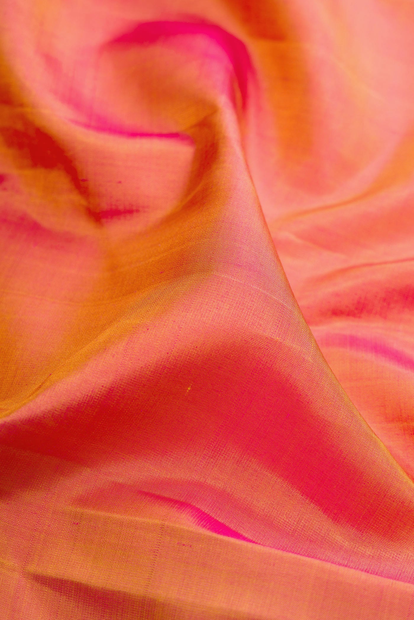 Close up of Pinkish Yellow Dual Tone Kanchipuram Silk Saree with Plain Body and Fancy Border.  displaying folds