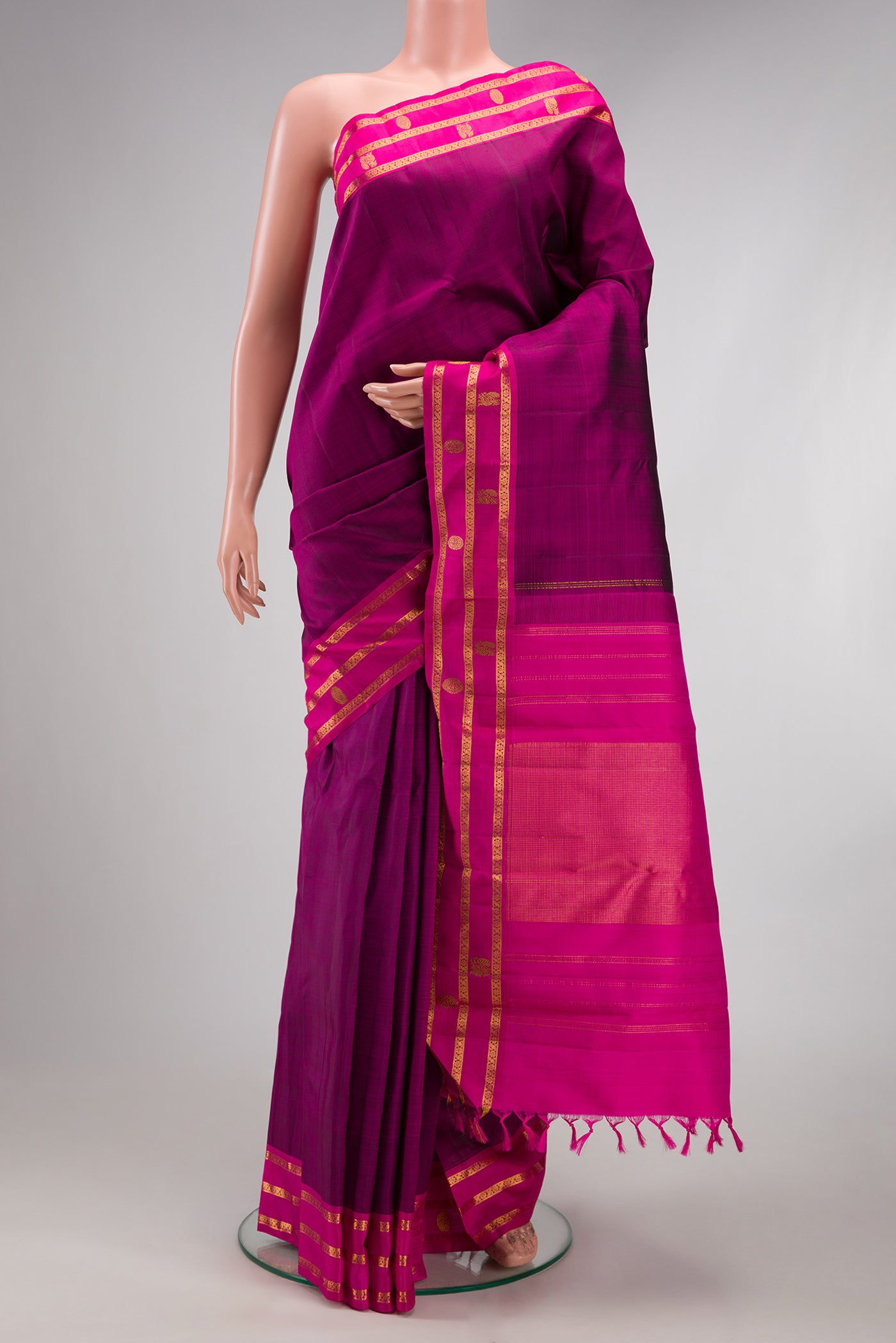 Purple Kanchipuram Silk Saree with Plain Body and Zari Border.  displayed on a mannequin