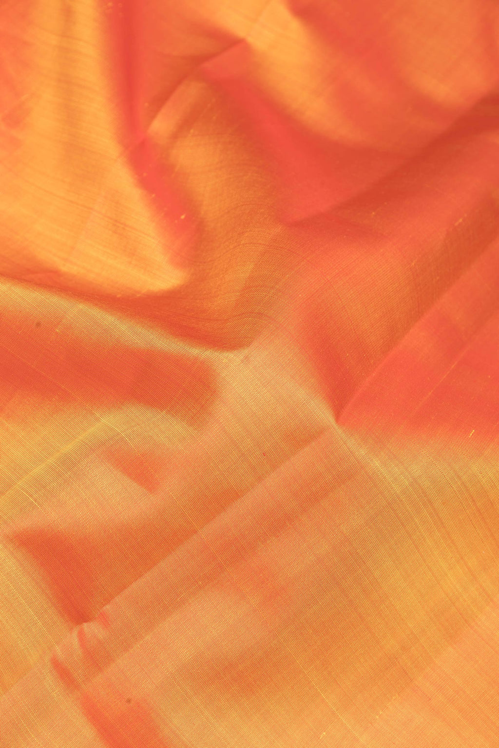 Close up of Rust Kanjivaram Silk Saree with Plain Body and Zari Border.  displaying folds
