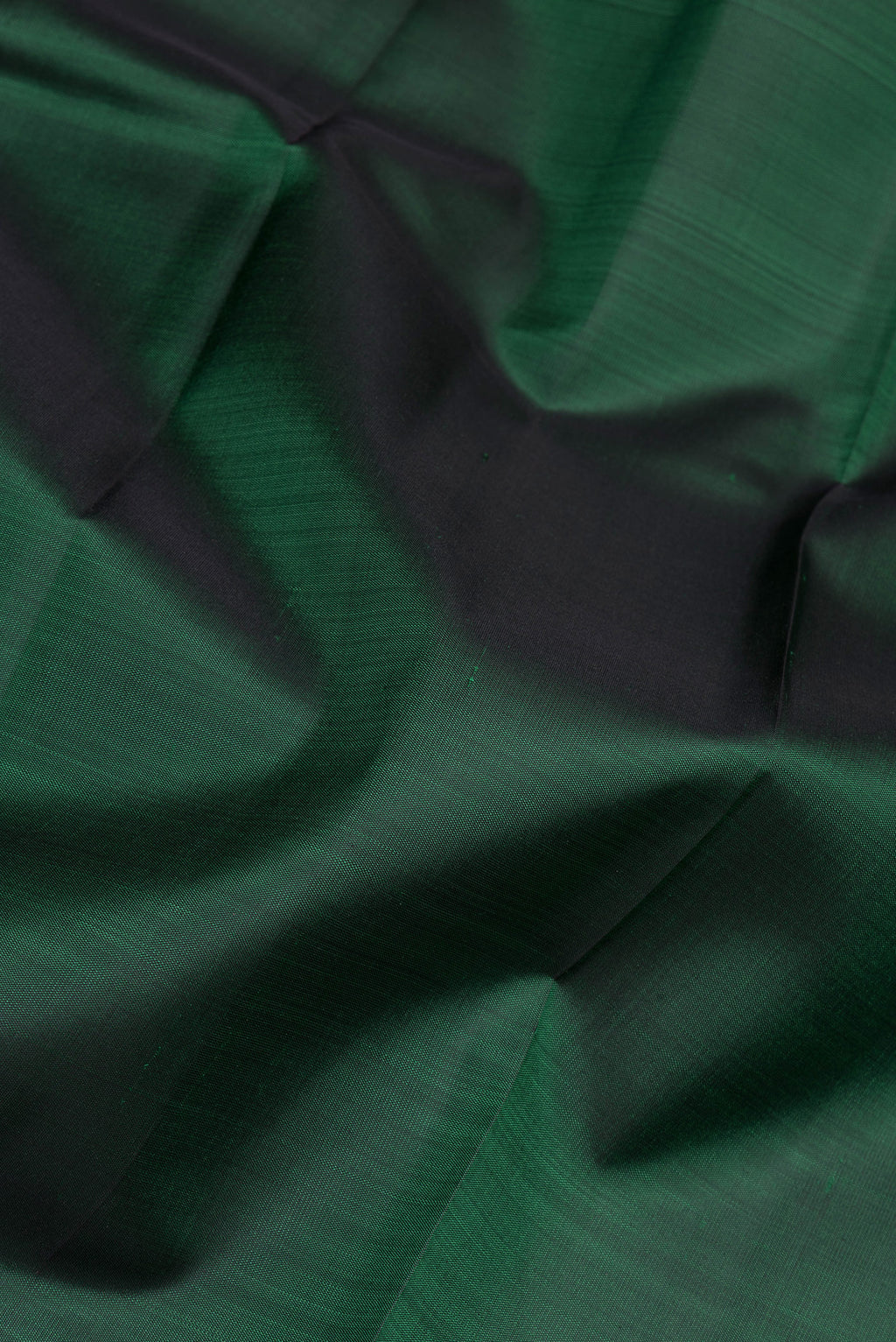 Close up of Bottle Green Kanjivaram Silk Saree with Plain Body and Zari Border.  displaying folds
