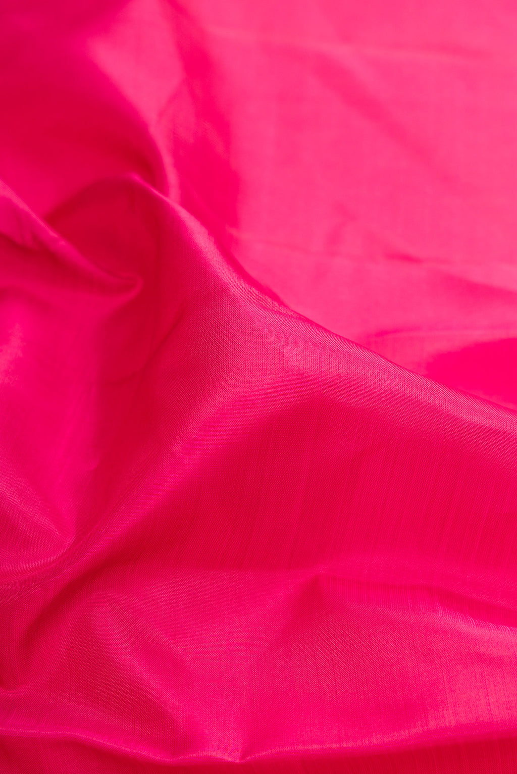 Close up of Pink Kanjivaram Silk Saree with Plain Body and Zari Border.  displaying folds