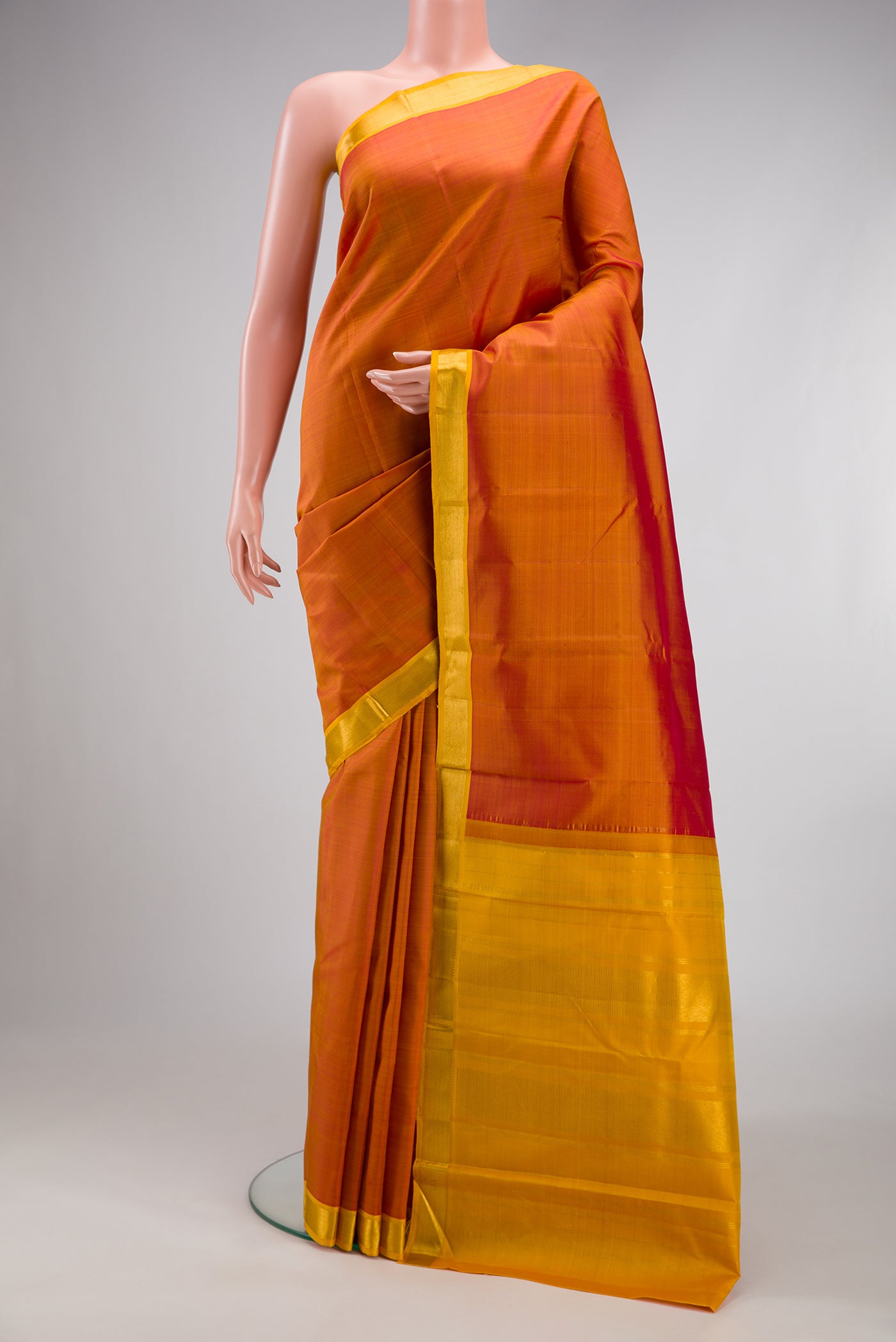Brick Orange Kanjivaram Silk Saree with Plain Body and Zari Border.  displayed on a mannequin