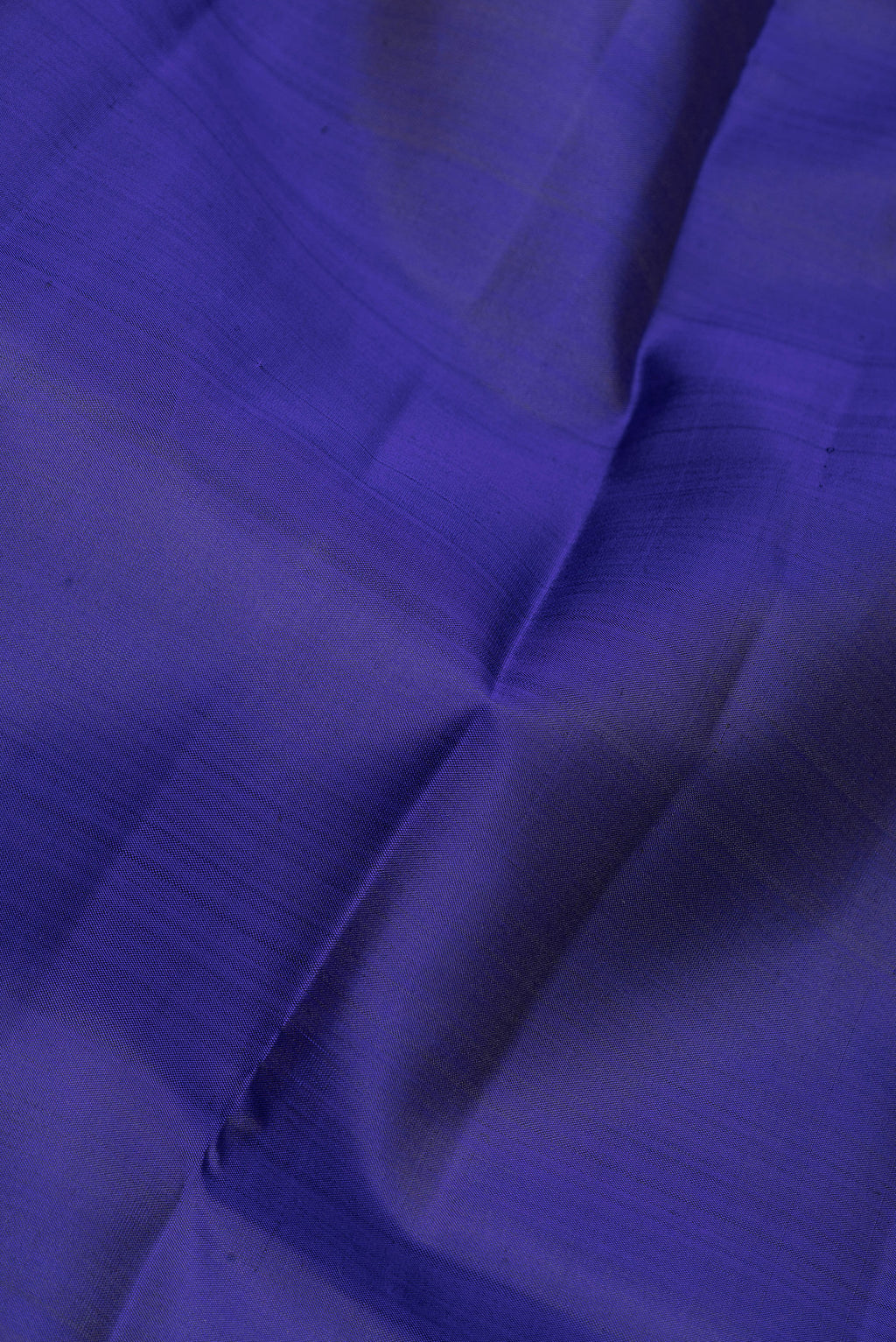 Close up of Blue Kanjivaram Silk Saree with Plain Body and Zari Border.  displaying folds