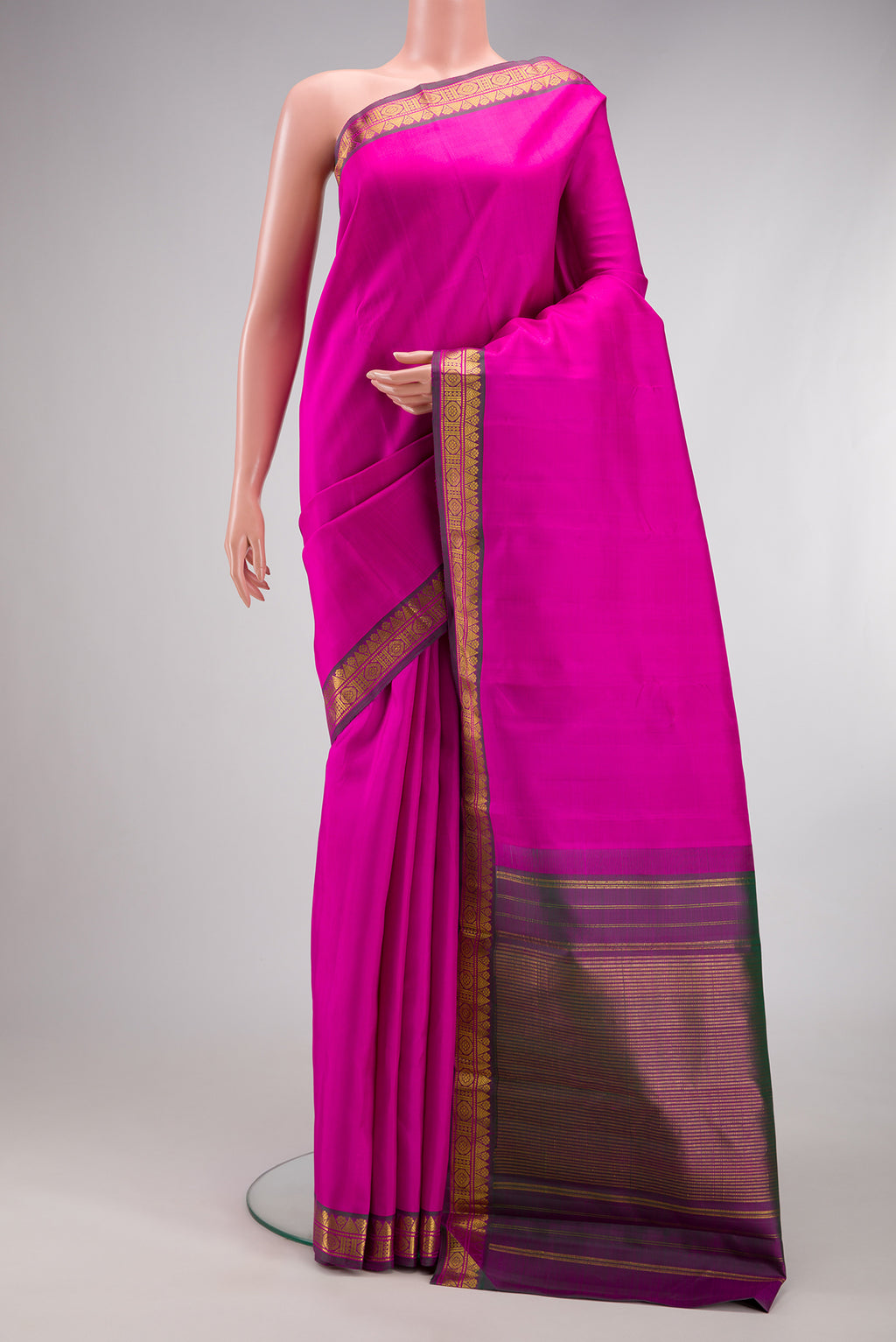 Magenta Kanchipuram Silk Saree with Plain Body and Zari Border.  displayed on a mannequin