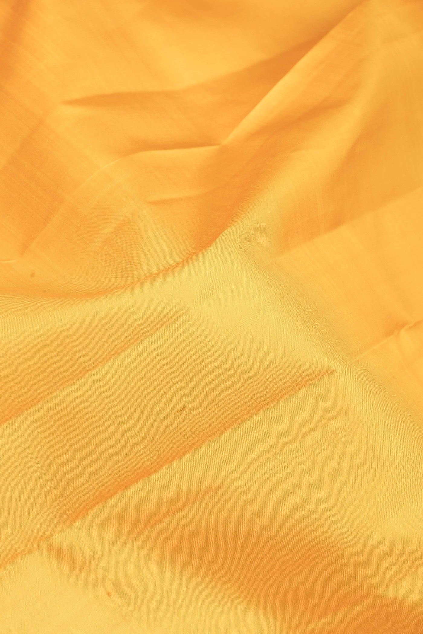Close up of Yellow Kanchipuram Silk Saree with Plain Body and Zari Border.  displaying folds