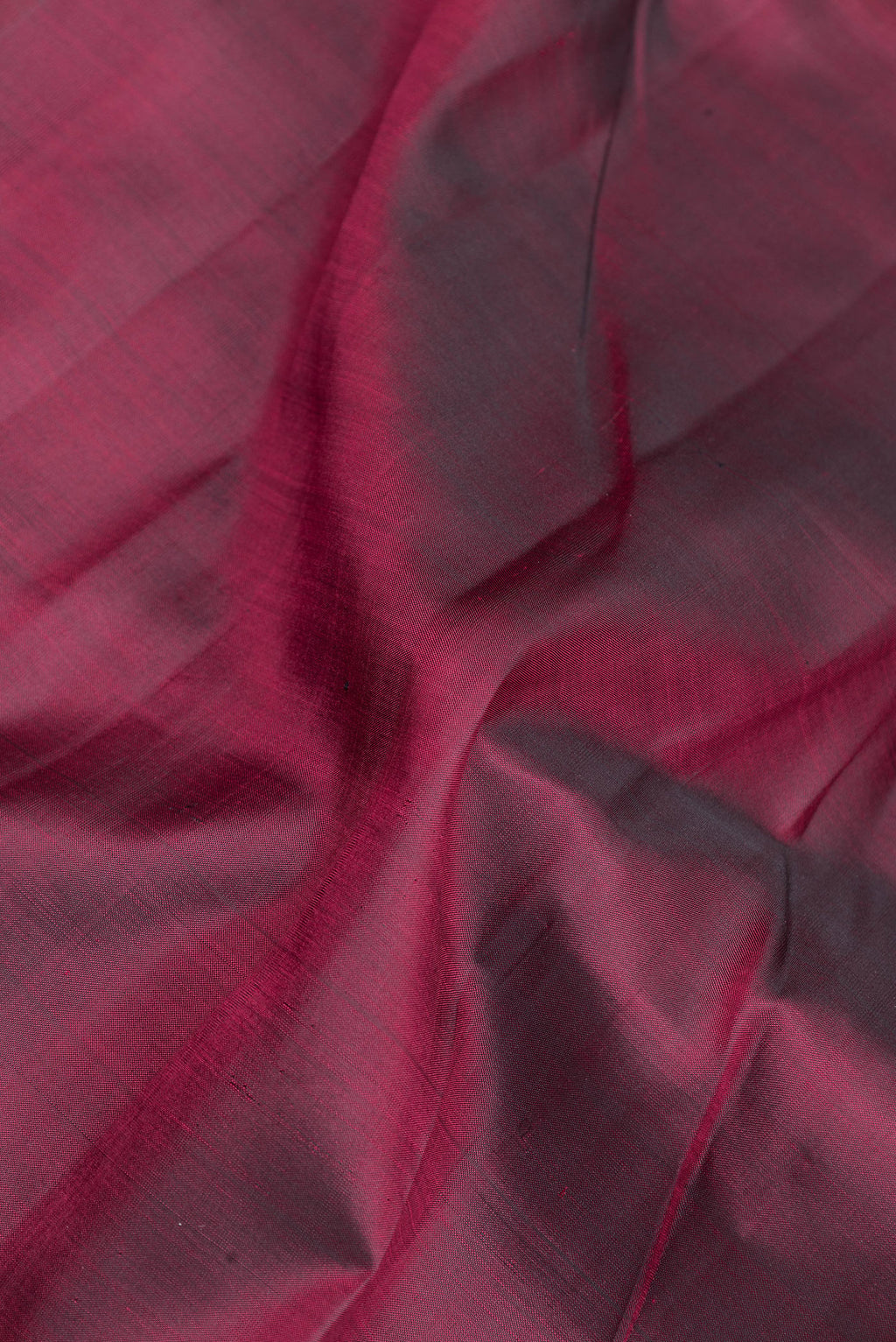 Close up of Maroon Kanchipuram Silk Saree with Plain Body and Zari Border.  displaying folds