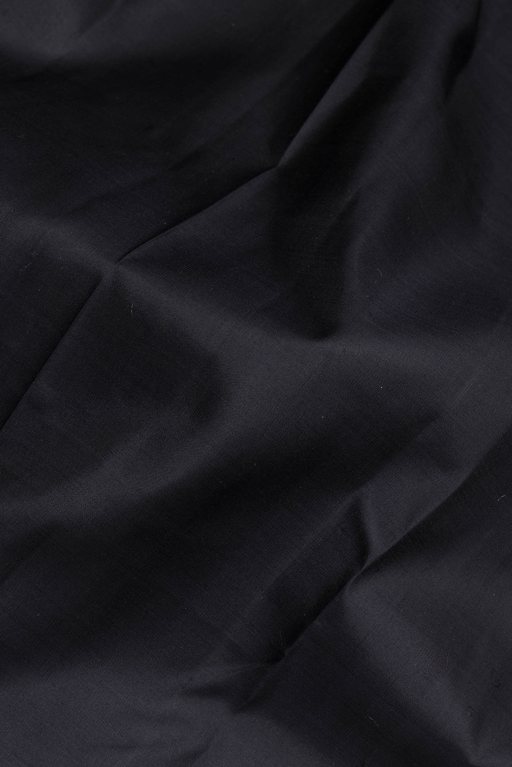 Close up of Black Kanchipuram Silk Saree with Plain Body and Zari Border.  displaying folds