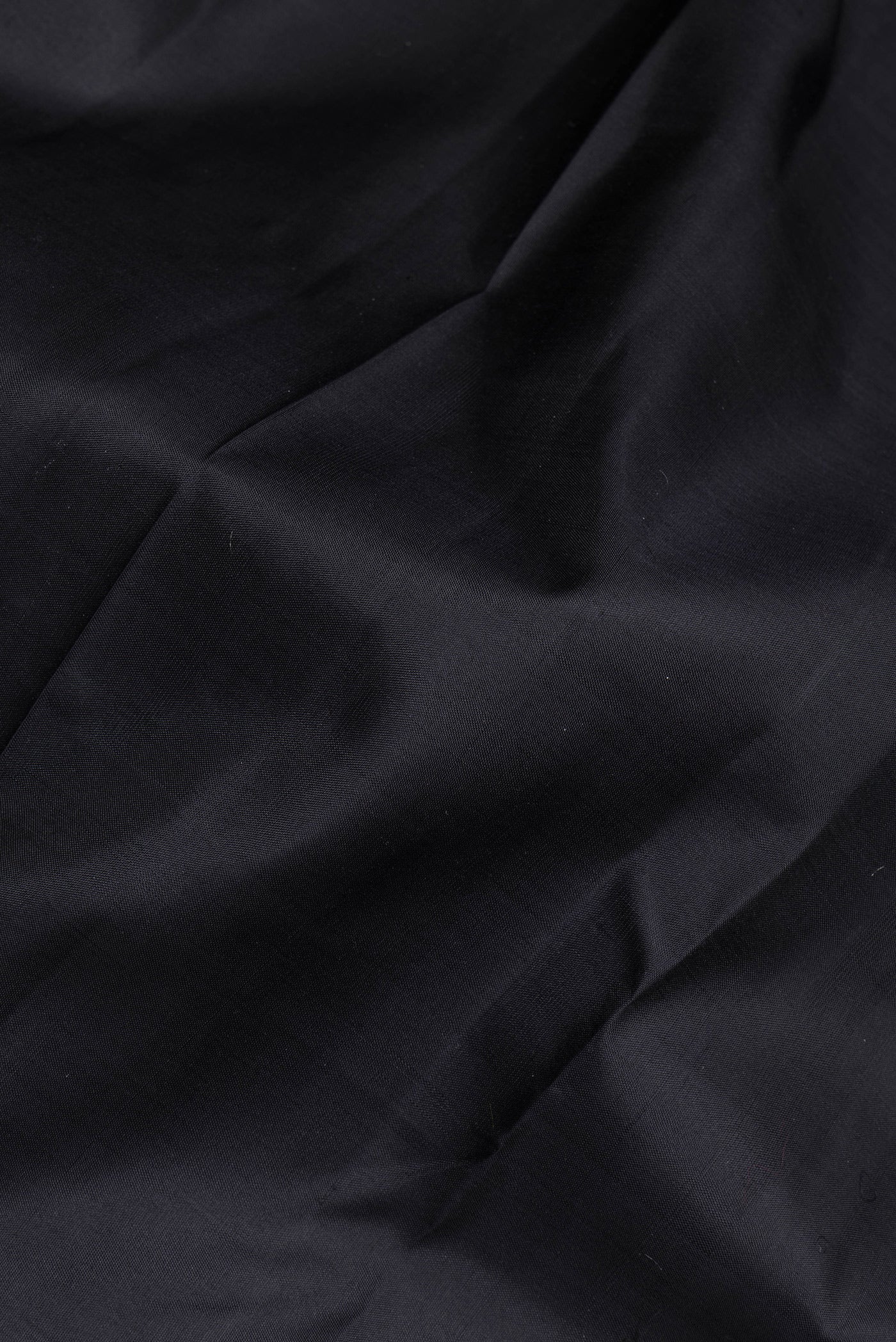 Close up of Black Kanchipuram Silk Saree with Plain Body and Zari Border.  displaying folds