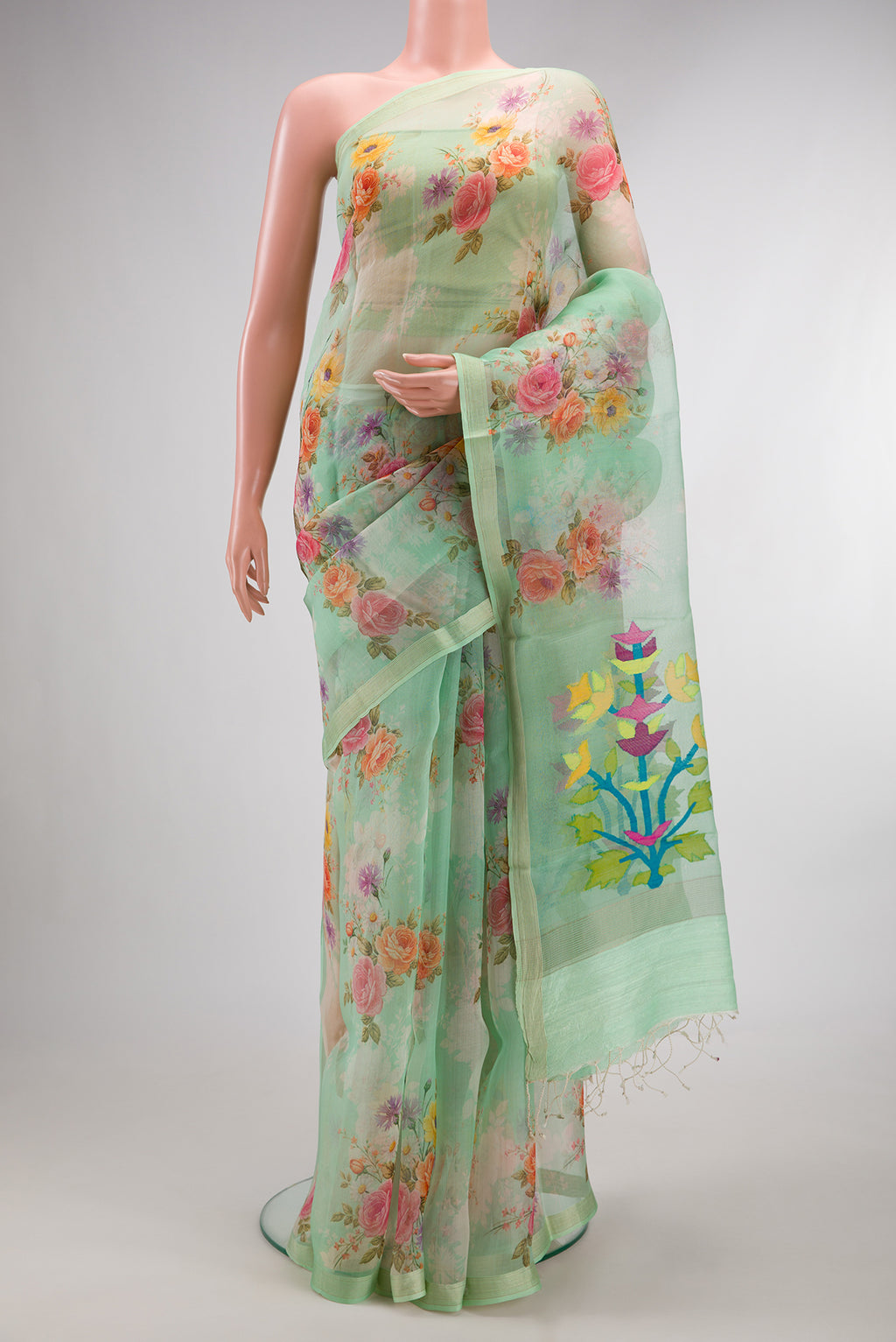 Pista Green Organza Saree with Floral Print on the body and Zari Border.  displayed on a mannequin