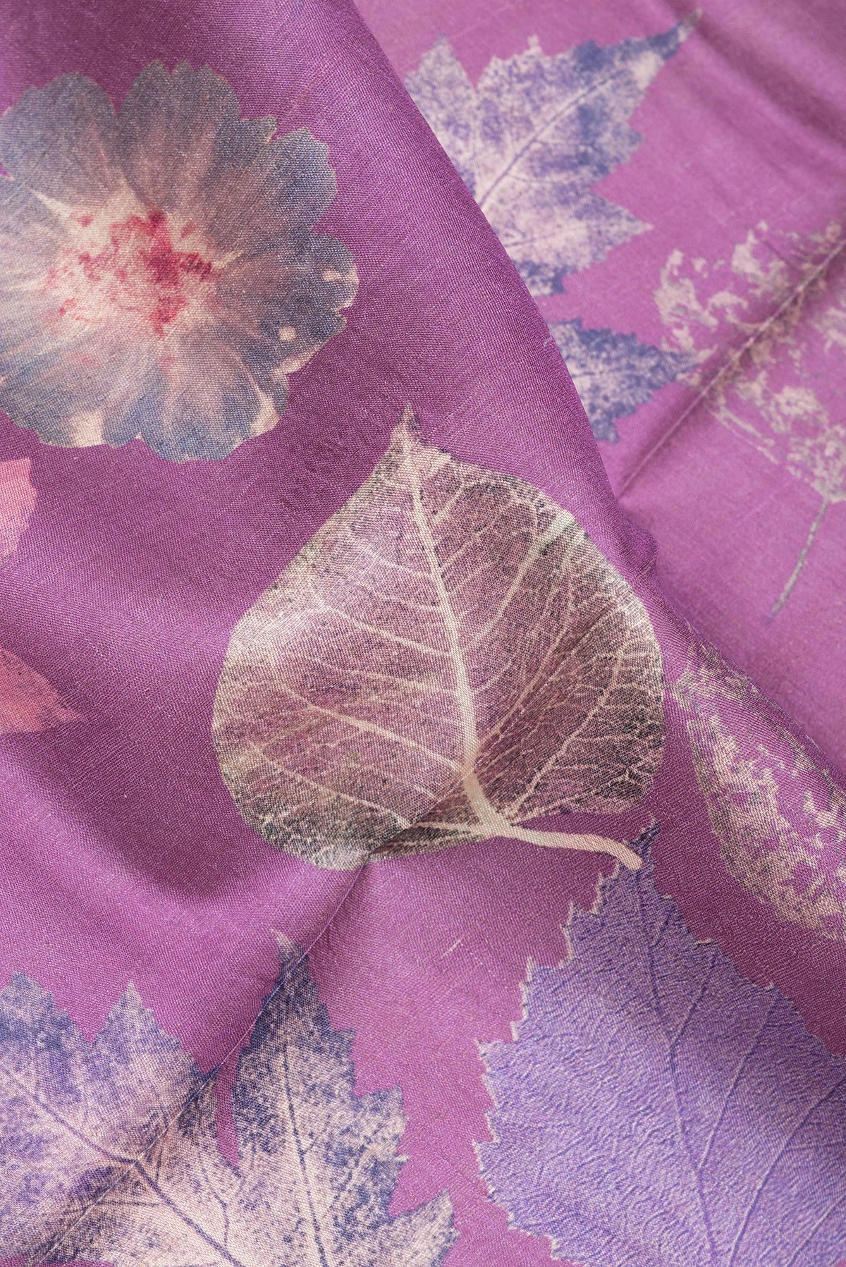 Close up of Purple Tussar Saree with Printed design on the body and Zari Border.  displaying folds