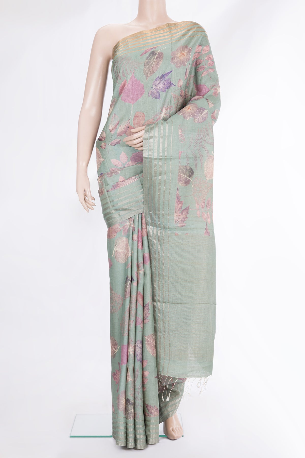 Sage Green Tussar Saree with Printed design on the body and Thin Zari Line.  displayed on a mannequin
