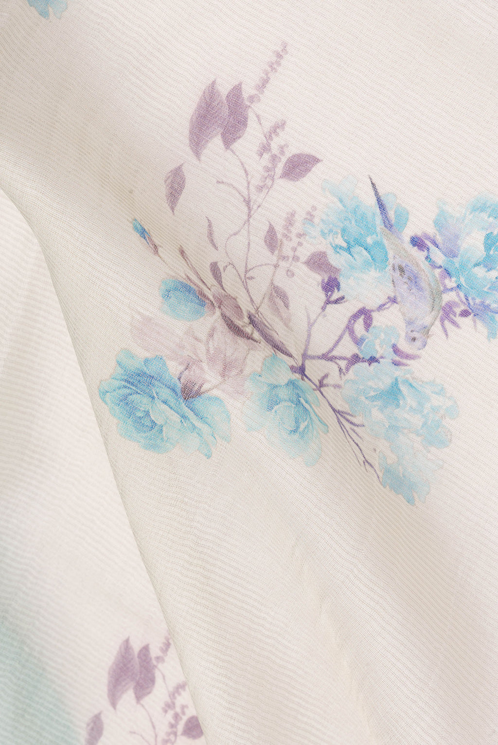 Close up of Cream Tussar Saree with Floral Print on the body and Fancy Border.  displaying folds