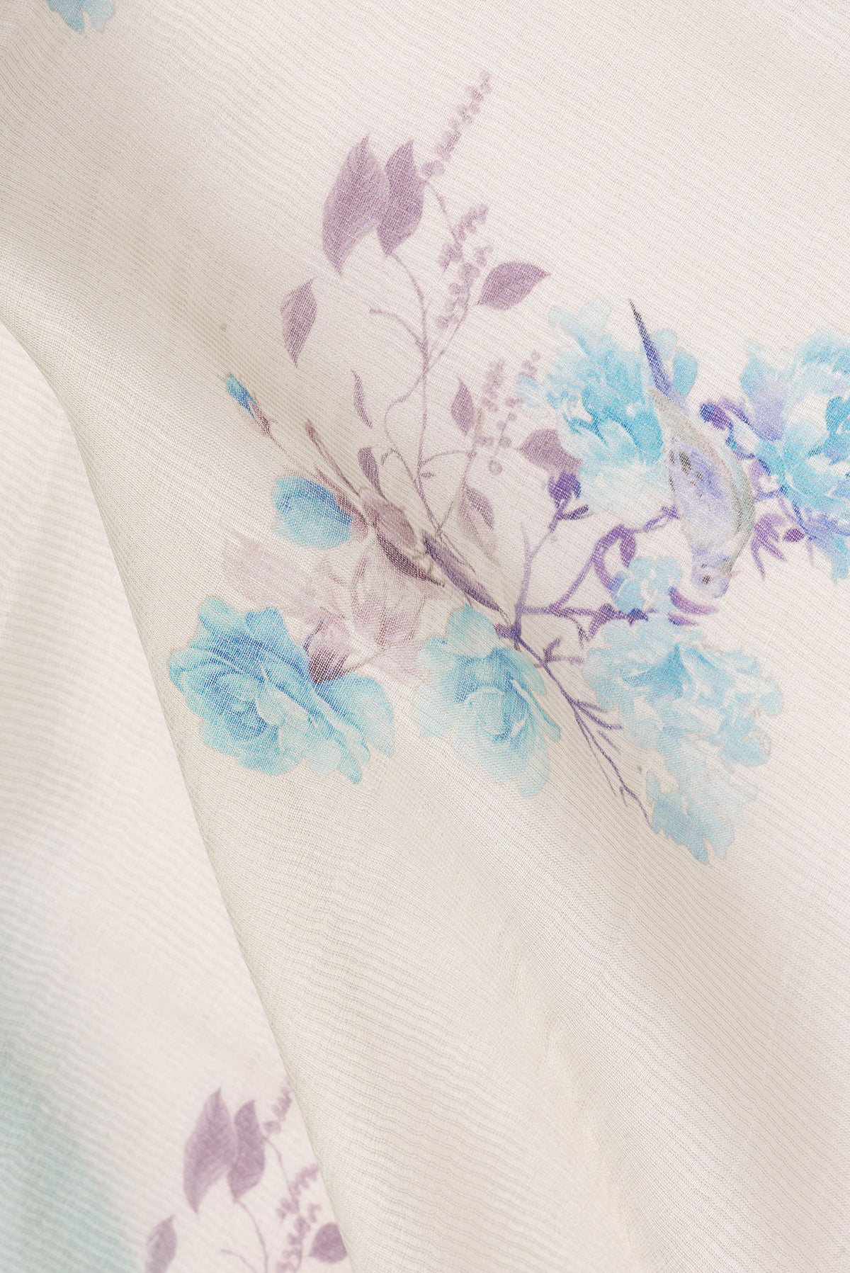 Close up of Cream Tussar Saree with Floral Print on the body and Fancy Border.  displaying folds