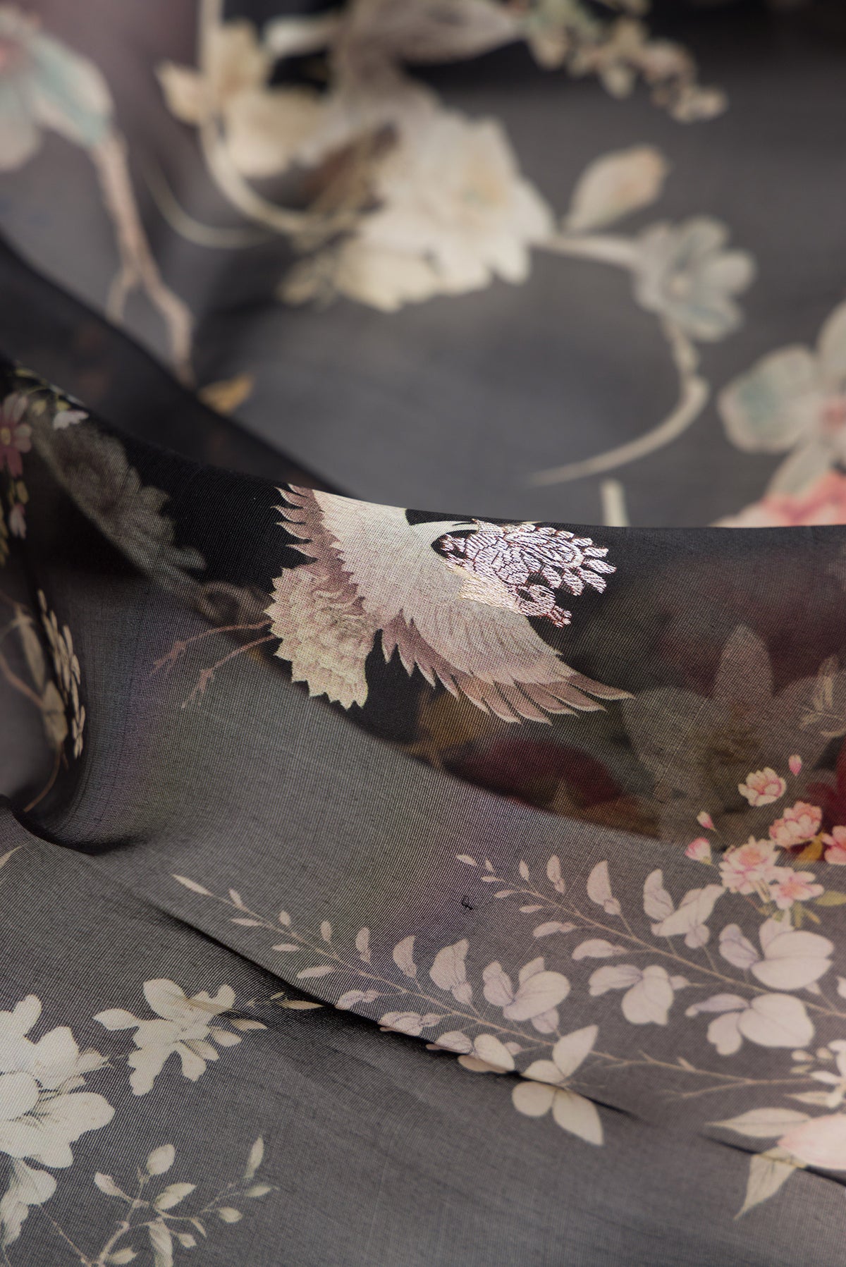 Close up of Black Organza Saree with Floral Print on the body and Fancy Border.  displaying folds