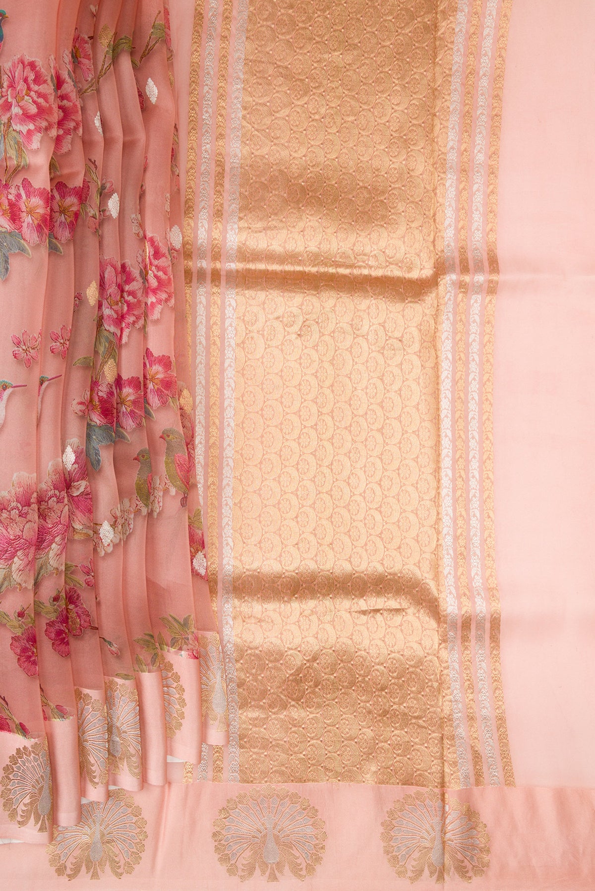 Pleats and pallu of Golden Peach Organza Saree with Printed design on the body and Fancy Border. 