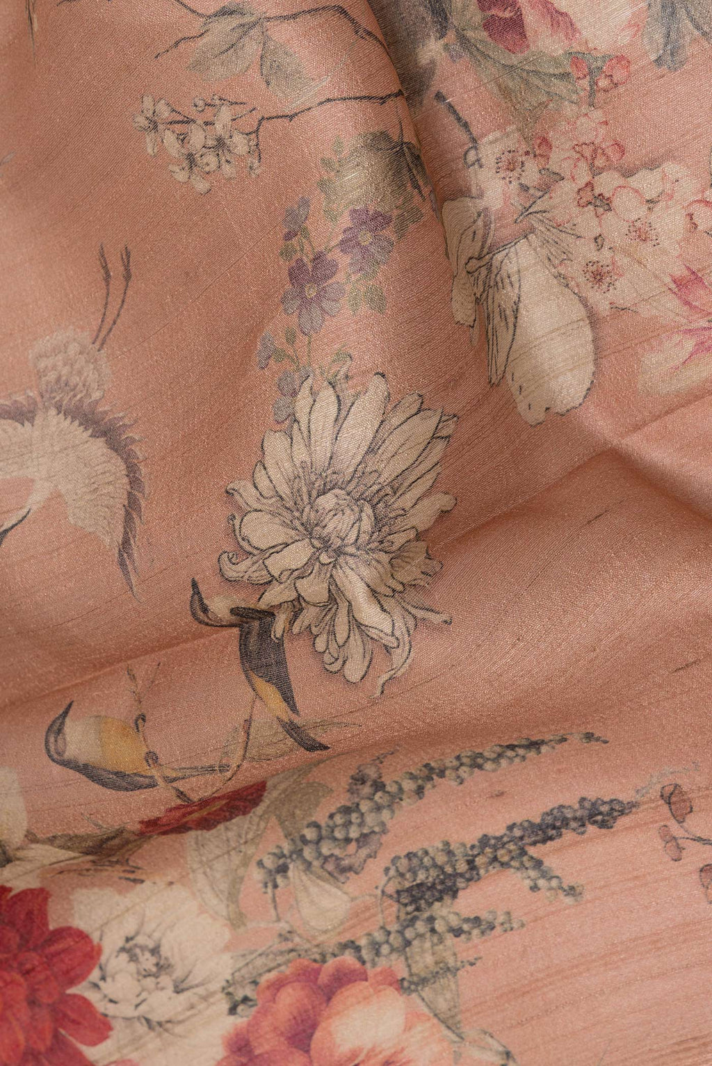 Close up of Rose Gold Tussar Saree with Floral Print on the body and Zari Border.  displaying folds