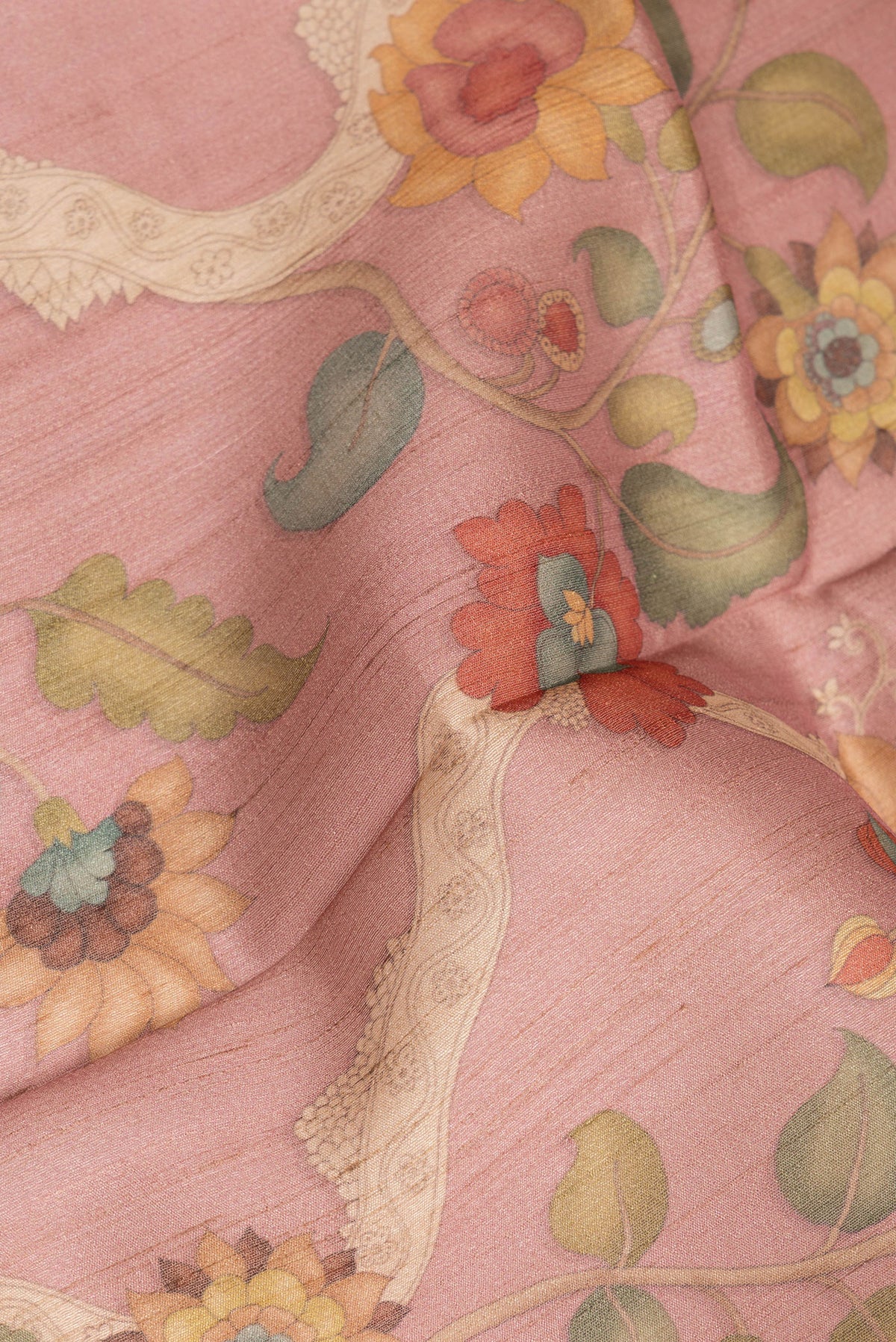 Close up of Peach Tussar Saree with Printed design on the body and Zari Border.  displaying folds