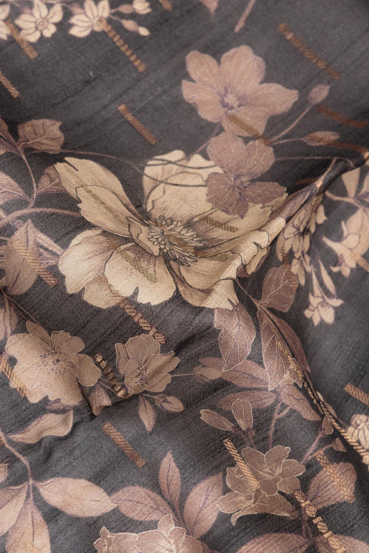 Close up of Pure Silk Black Tussar Saree with Printed design on the body and Zari Border.  displaying folds