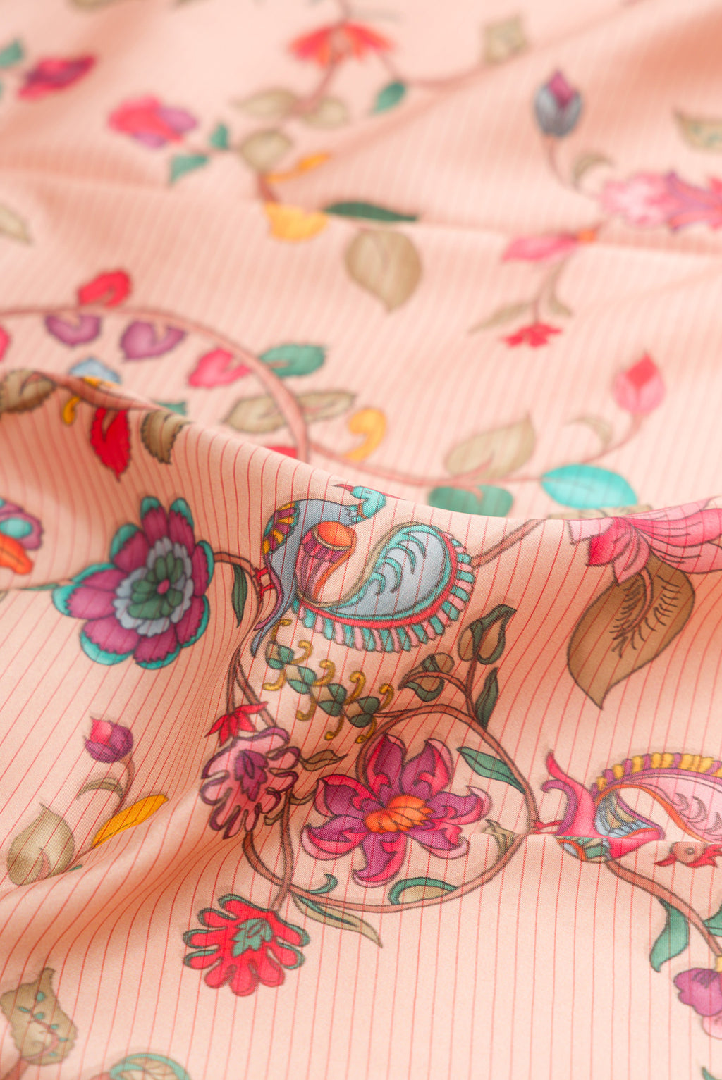 Close up of Peach Kanchipuram Silk Saree with Printed design on the body and Plain Border.  displaying folds