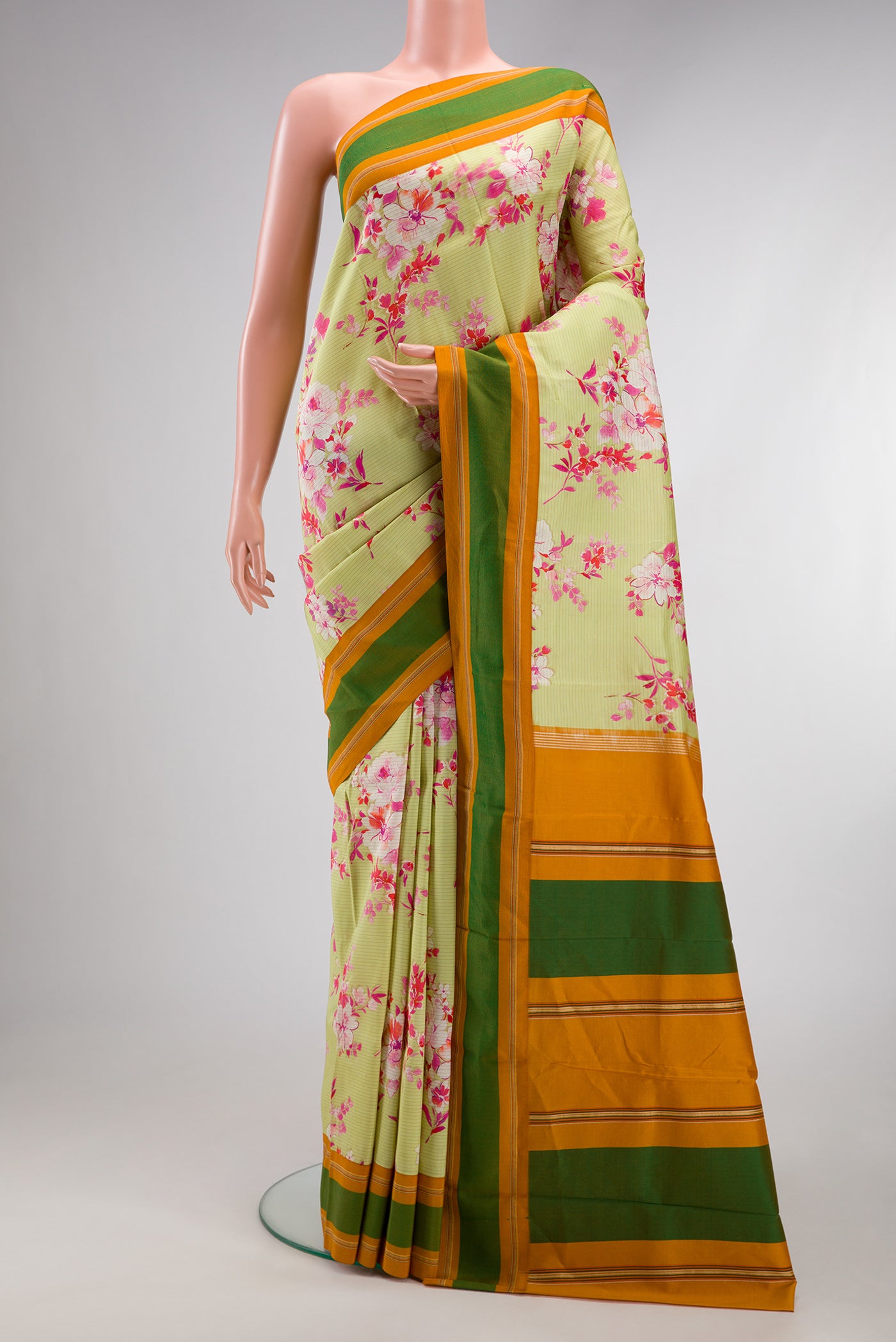 Pista Green Kanchipuram Silk Saree with Printed design on the body and Plain Border.  displayed on a mannequin