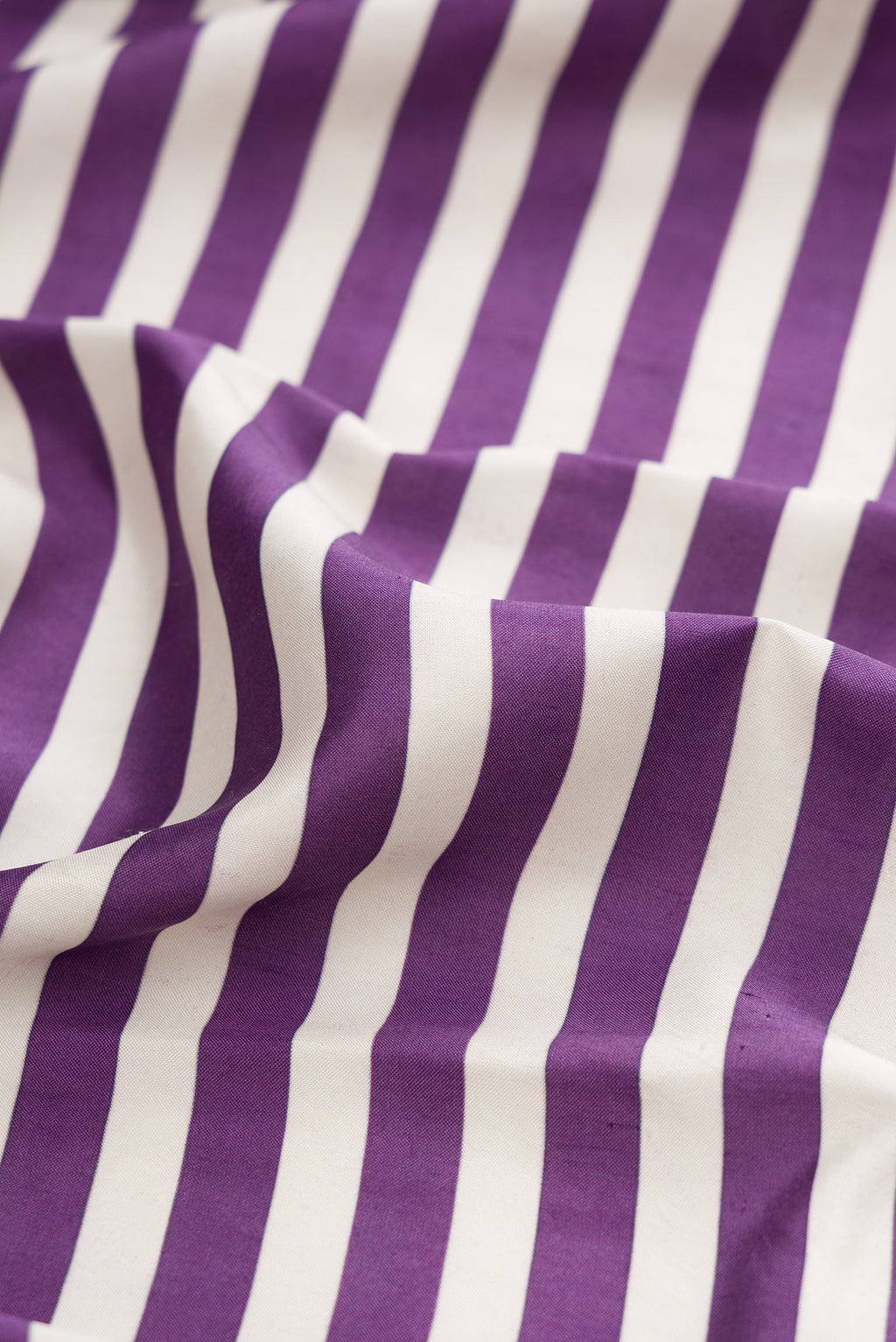 Close up of Purple Kanchipuram Silk Saree with Printed design on the body and Ikat Border.  displaying folds