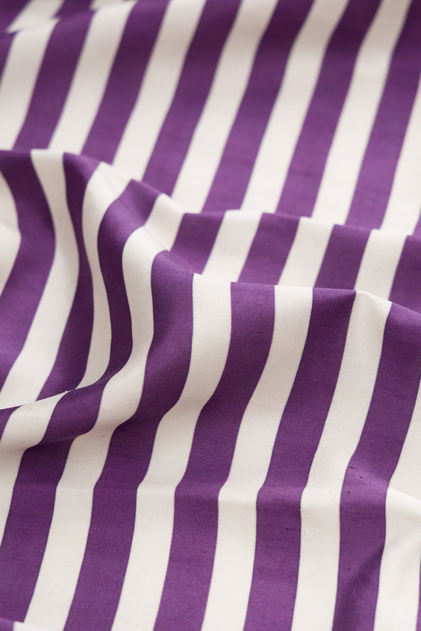 Close up of Purple Kanchipuram Silk Saree with Printed design on the body and Ikat Border.  displaying folds