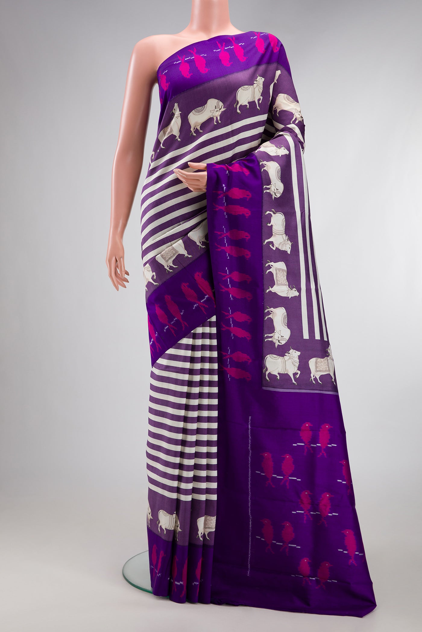 Purple Kanchipuram Silk Saree with Printed design on the body and Ikat Border.  displayed on a mannequin