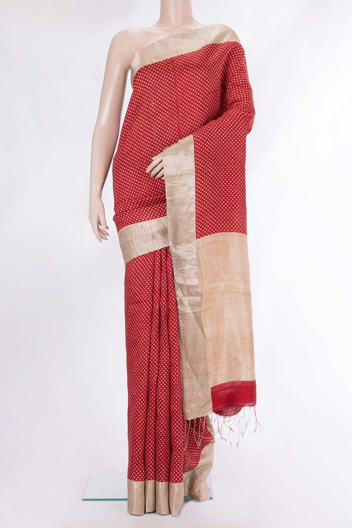 Red Tussar Saree with Bandhani Print on the body and Zari Border.  displayed on a mannequin