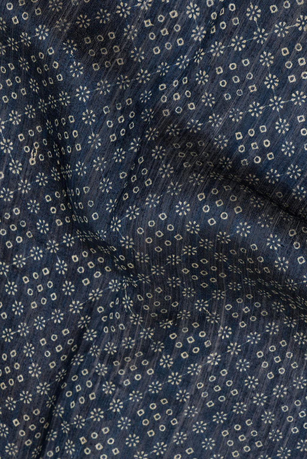 Close up of Navy Blue Tussar Saree with Bandhani Print on the body and Zari Border.  displaying folds