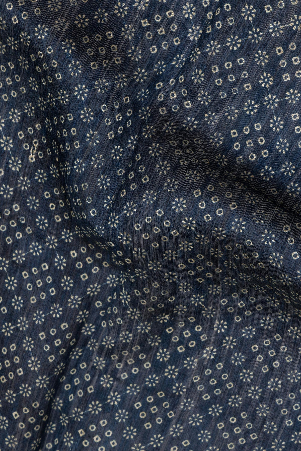 Close up of Navy Blue Tussar Saree with Bandhani Print on the body and Zari Border.  displaying folds