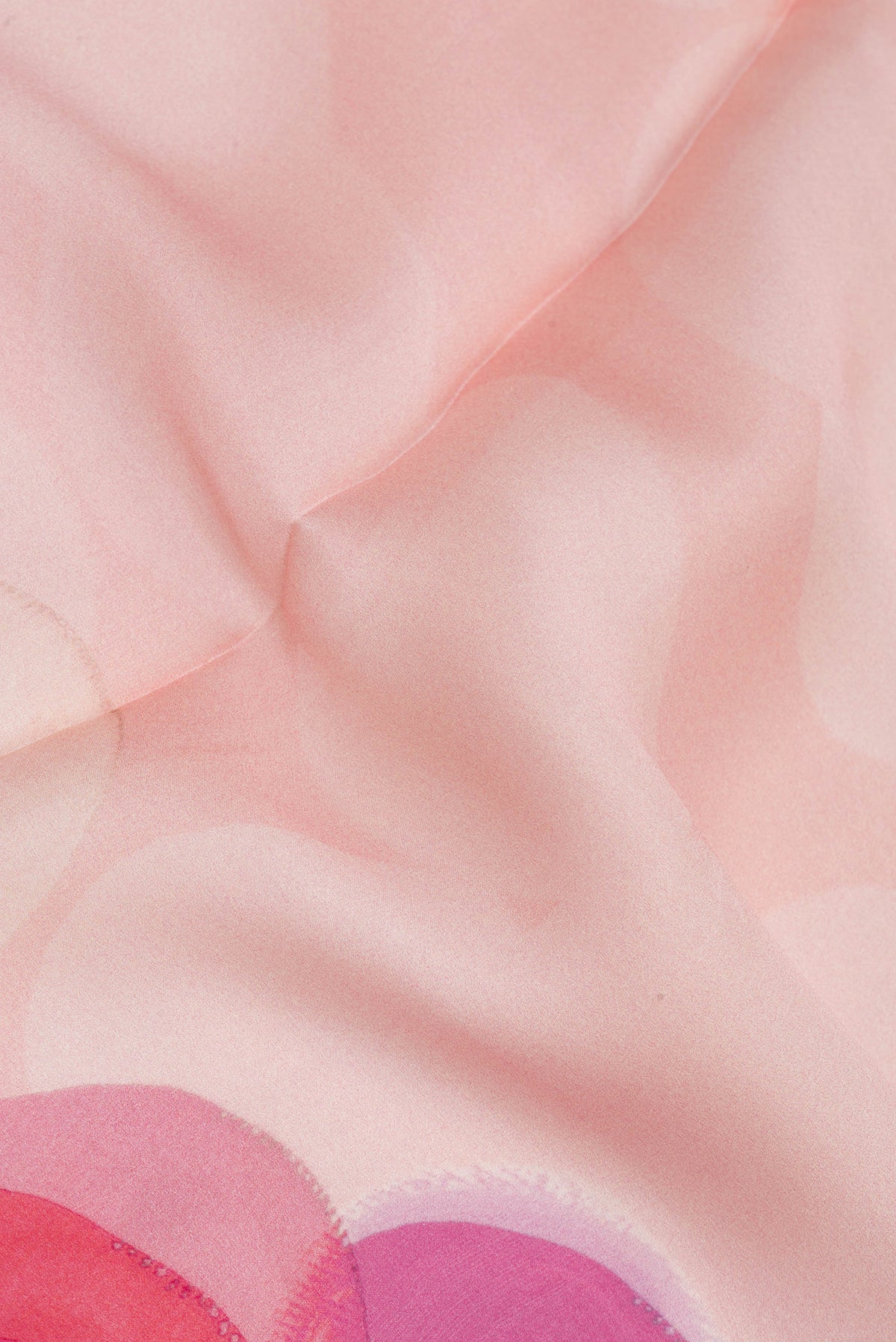 Close up of Rose Gold Crepe Saree with Floral Print on the body and Plain Border.  displaying folds