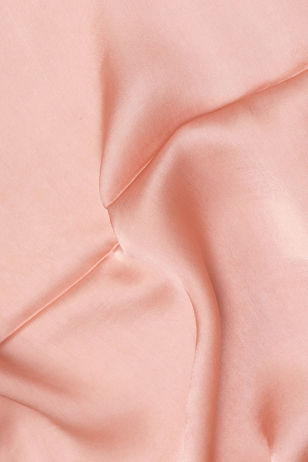 Close up of Peach Crepe Saree with Plain Body and Without Border.  displaying folds