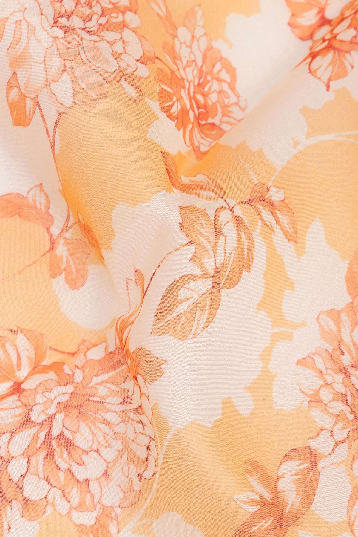 Close up of Orange Organza Saree with Floral Print on the body and Zari And Thread Border.  displaying folds