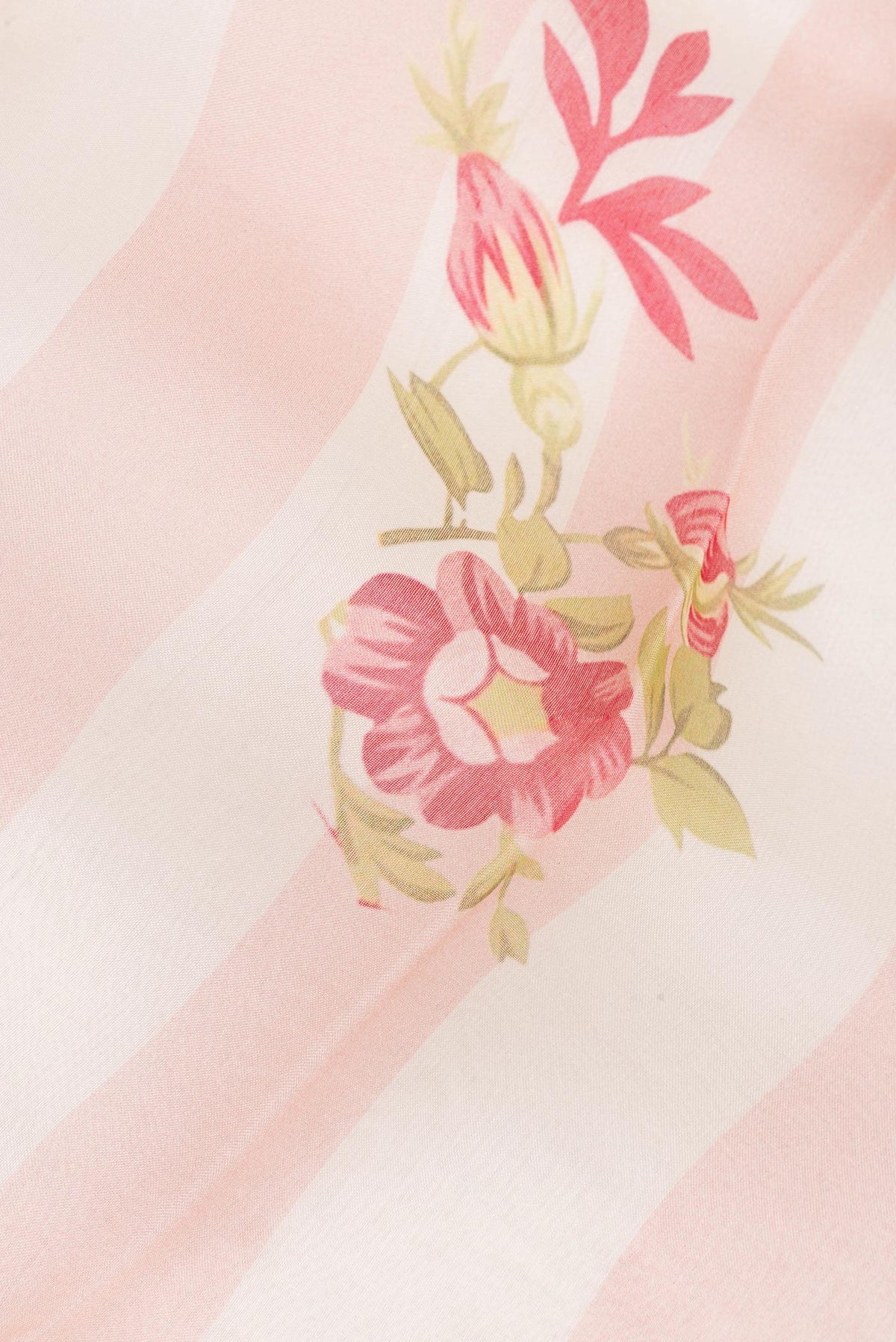 Close up of Peach Organza Saree with Floral Print on the body and Zari Border.  displaying folds