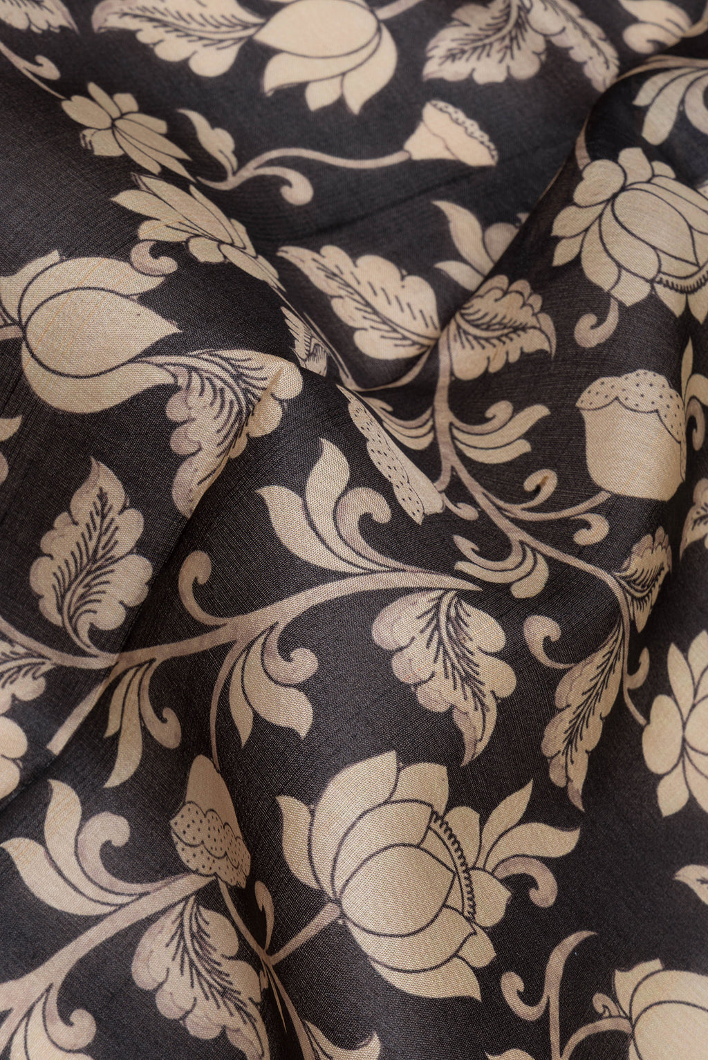 Close up of Black Tussar Saree with Printed design on the body and Zari Border.  displaying folds