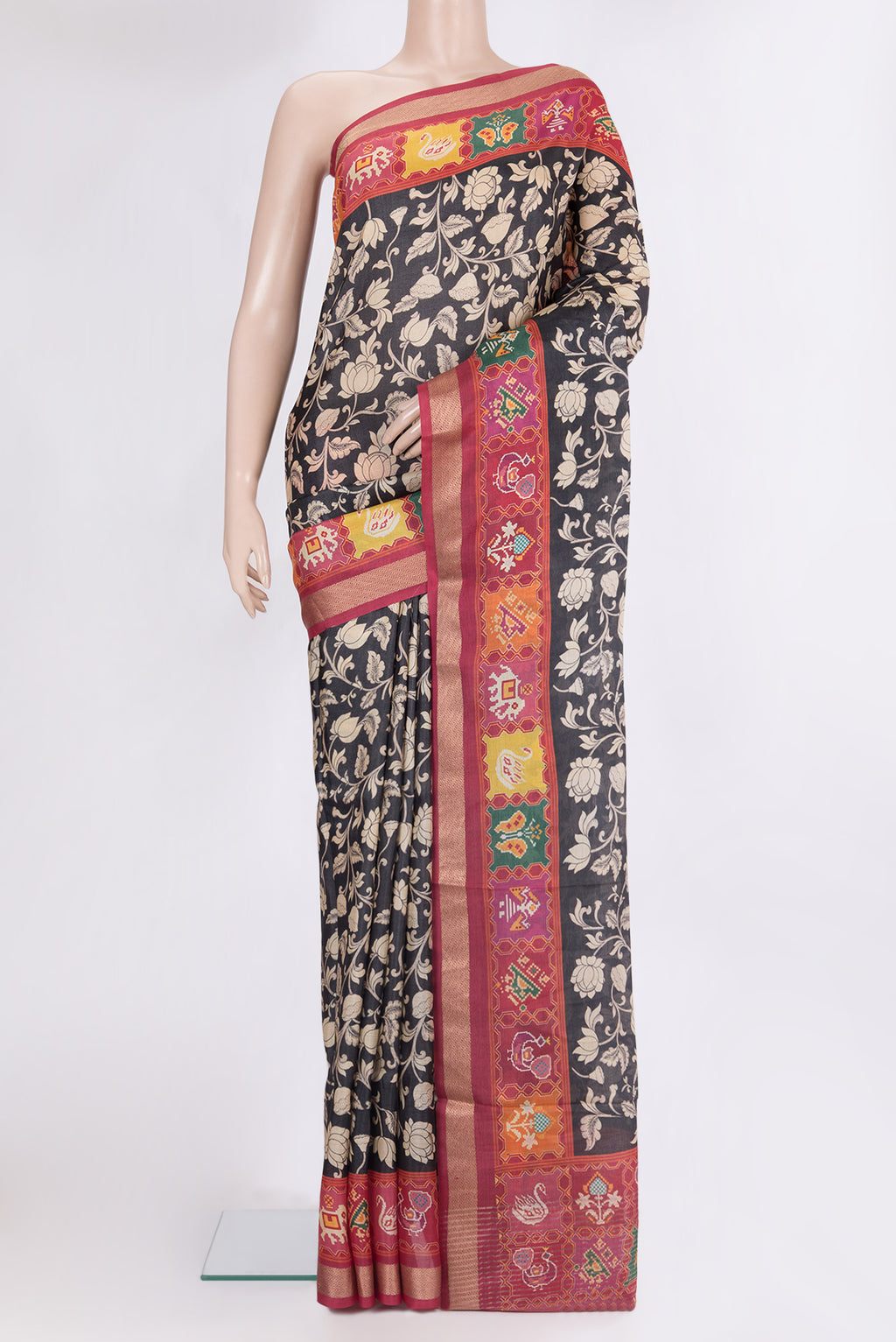 Black Tussar Saree with Printed design on the body and Zari Border.  displayed on a mannequin
