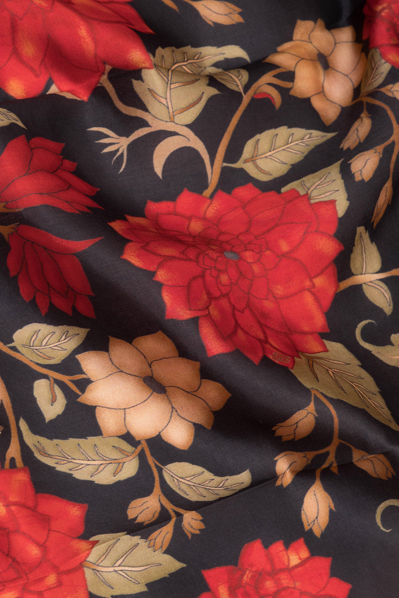 Close up of Black Tussar Silk Saree with Floral Print on the body and Fancy Border.  displaying folds