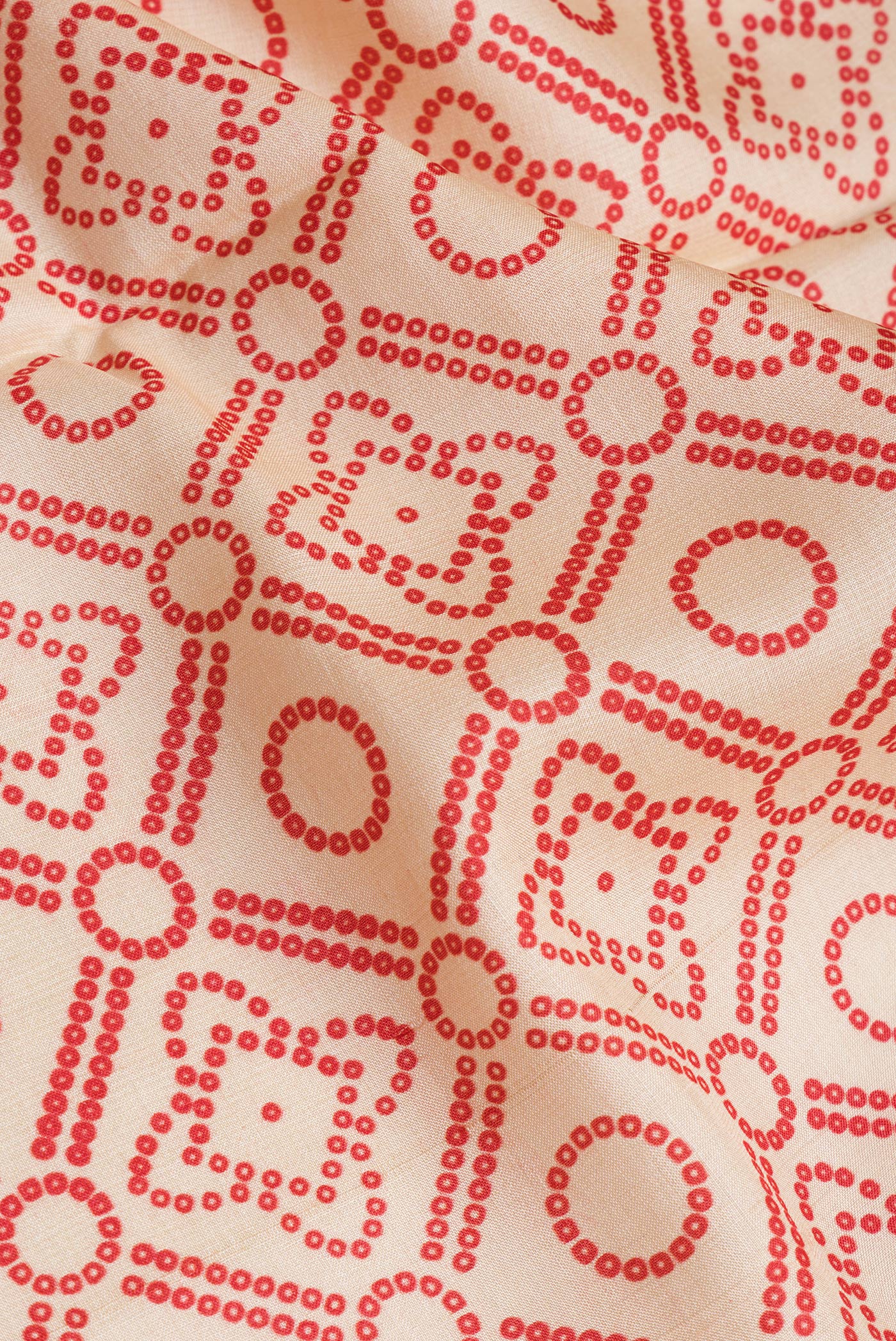 Close up of Beige Tussar Silk Saree with Bandhani Print on the body and Fancy Border.  displaying folds