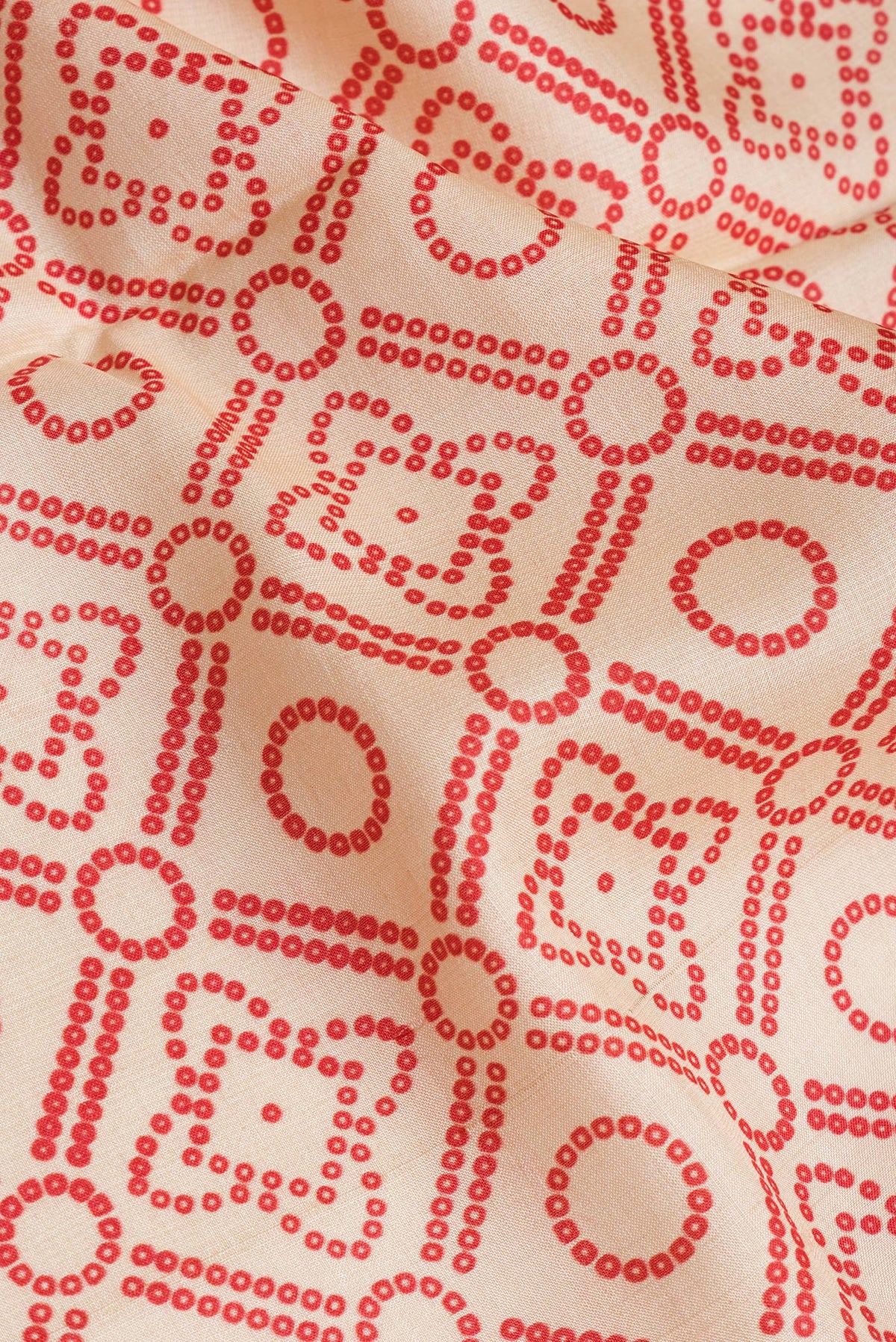 Close up of Beige Tussar Silk Saree with Bandhani Print on the body and Fancy Border.  displaying folds