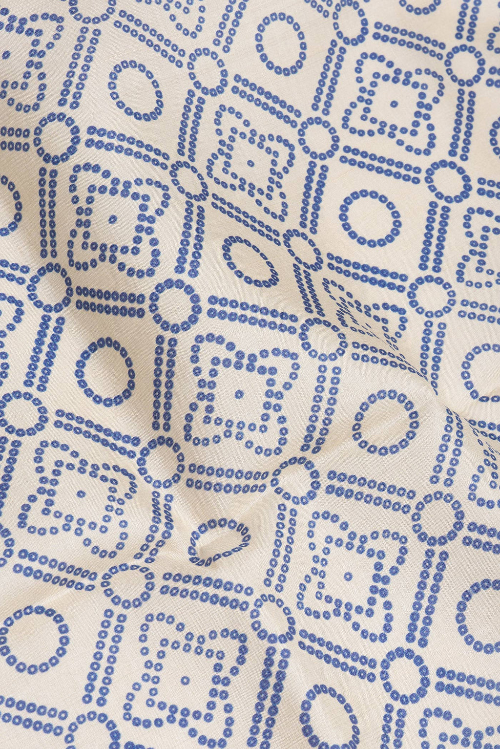 Close up of Beige Tussar Silk Saree with Bandhani Print on the body and Fancy Border.  displaying folds